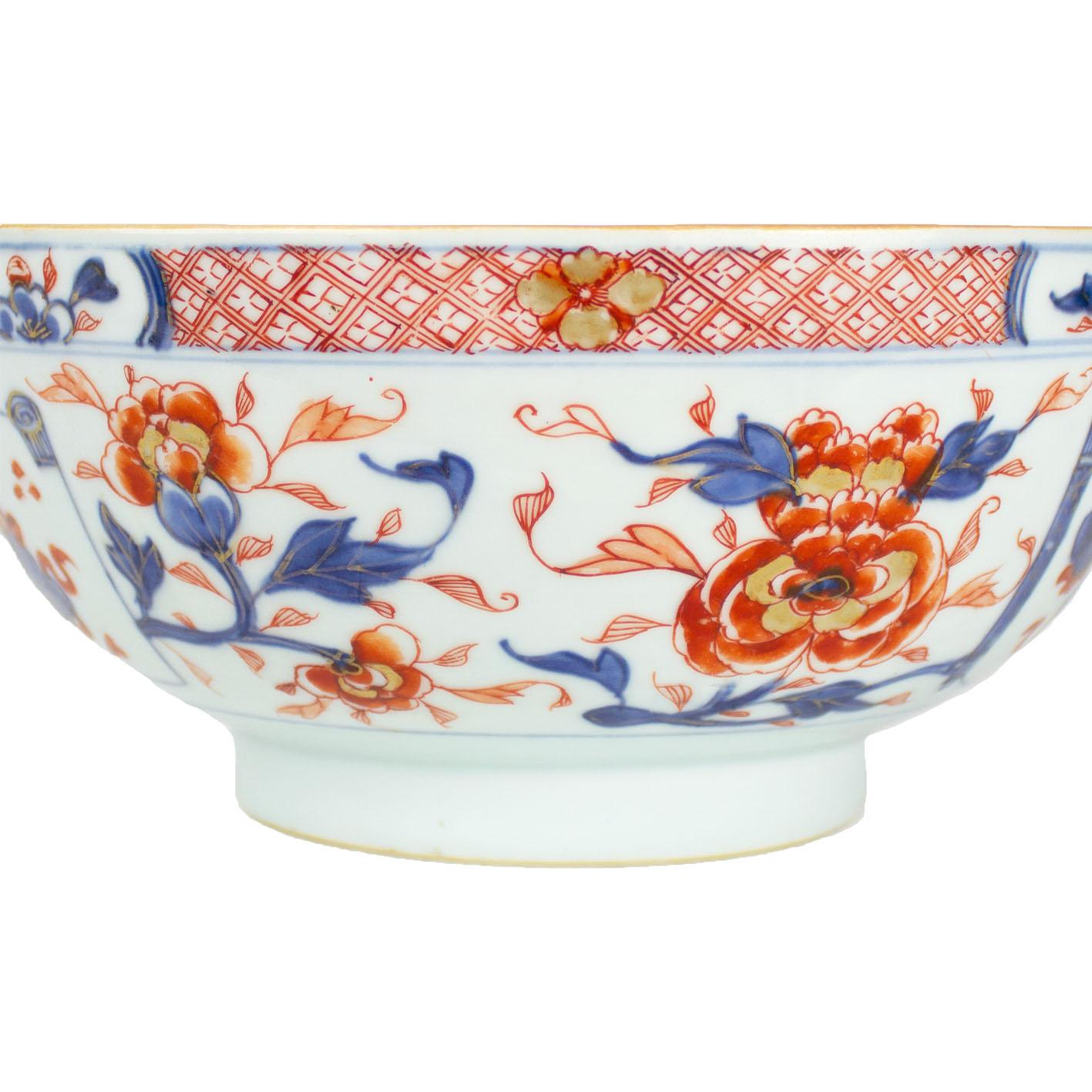 A Chinese porcelain bowl with rounded sides, East India Company, Qianlong period (1736-1795). Imari decoration with underglaze blue, rouge-de-fer and touches of gilt enamels. Both inside and outside rim are decorated with four reserves containing