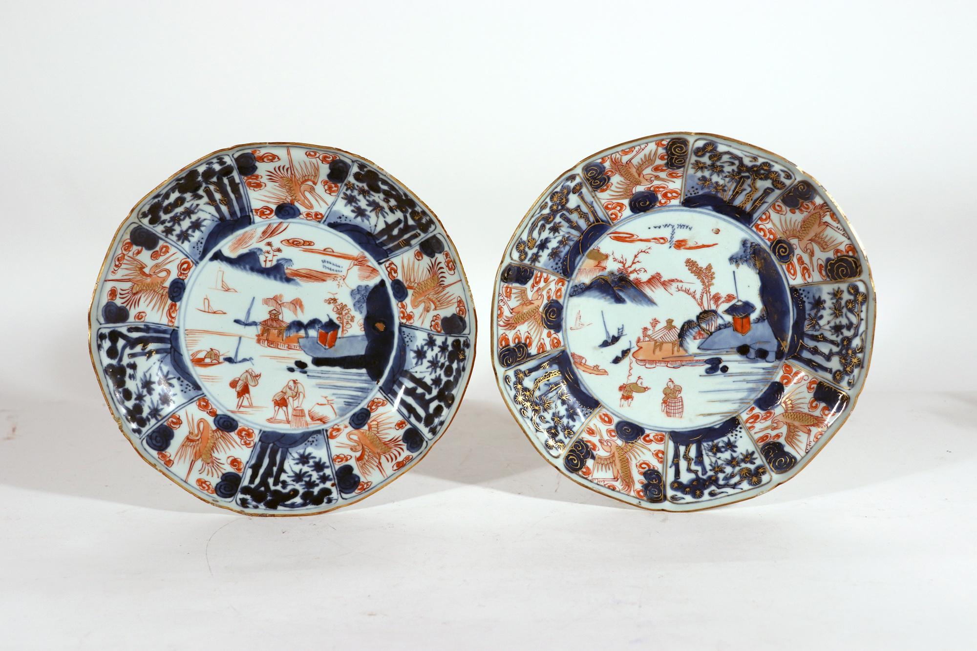Chinese Export porcelain Imari dishes,
18th century,

The pair of Chinese Export shaped saucer dishes have a central roundel with a riverside scene with buildings by the water with ships in the background. In the foreground are two figures, one