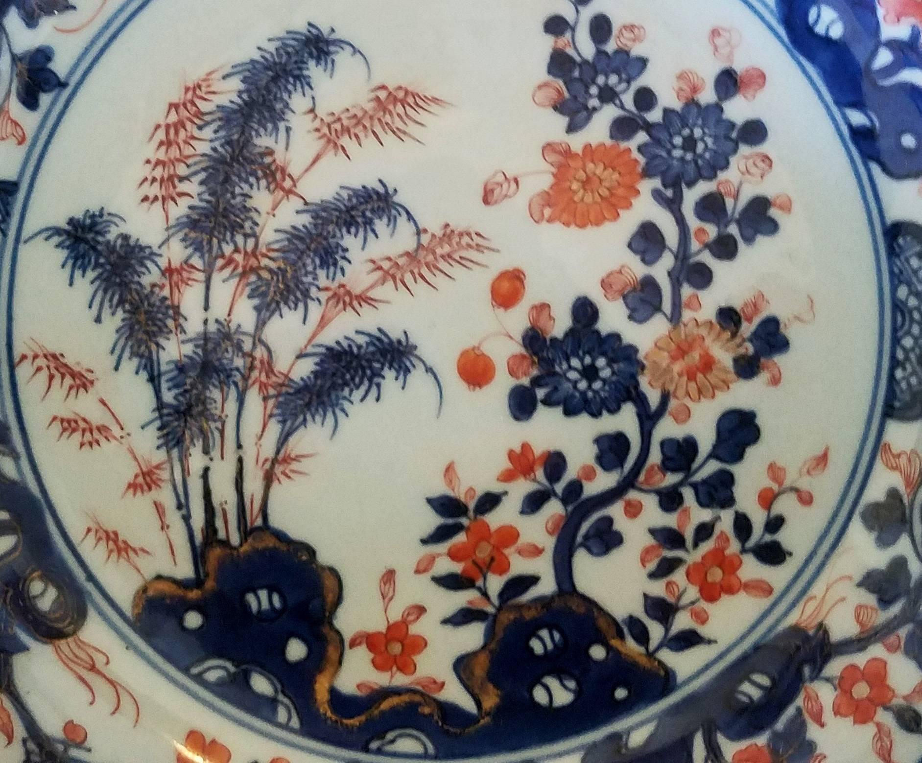 Chinese Export porcelain Imari saucer dish, 
circa 1770-1780.

The Chinese Imari porcelain large dish is painted in underglaze colors of red and blue with gilt highlights. The central scene depicts to the left a rock outcrop with bamboo plates