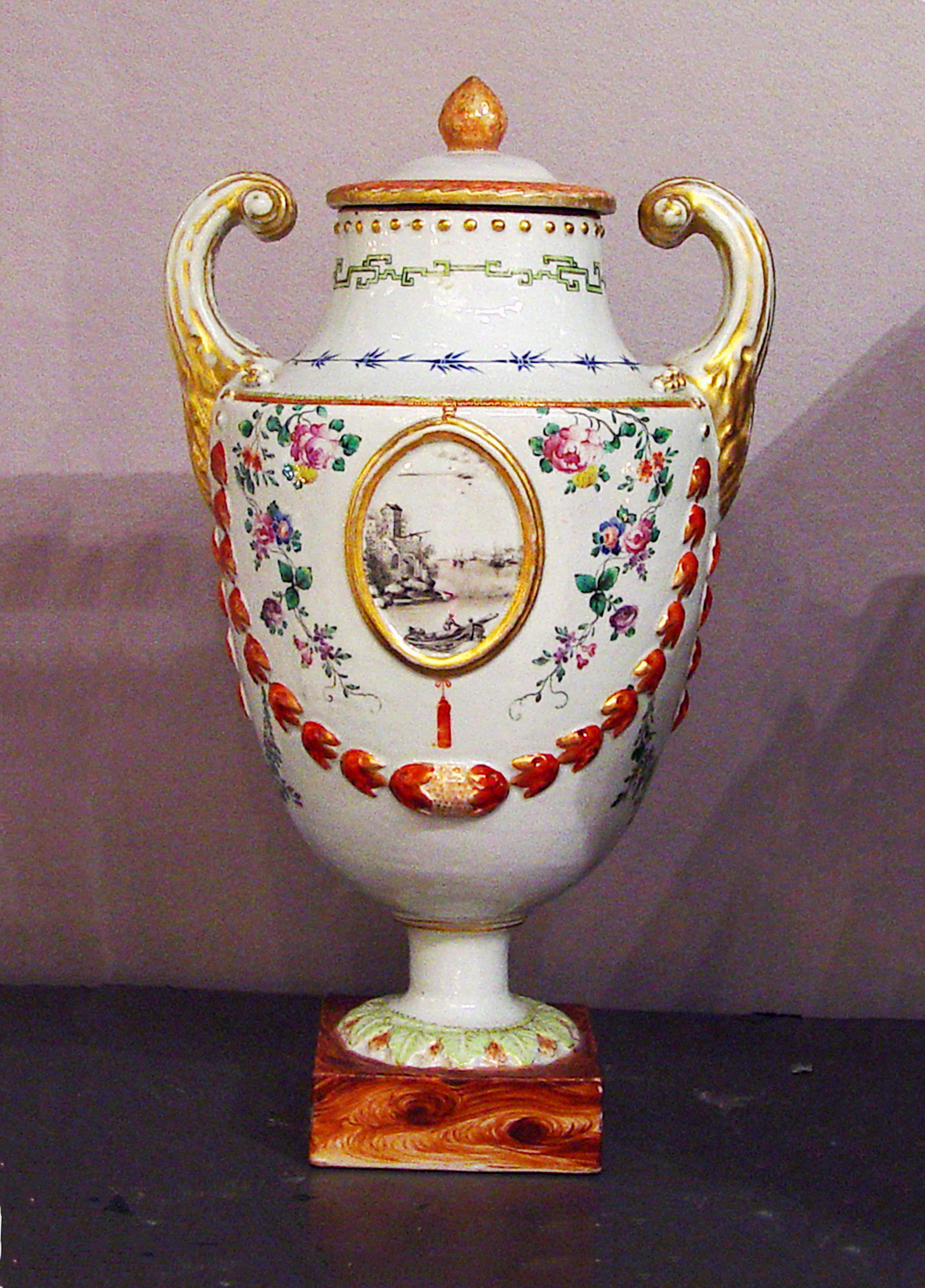 Chinese Export Porcelain Pistol-Handled Vase and Cover, 
Circa 1770.

This Chinese Export double-pistol-handled porcelain shape can be traced back to silver prototypes by Stefano della Bella (1610-1664) and became particularly popular in both silver