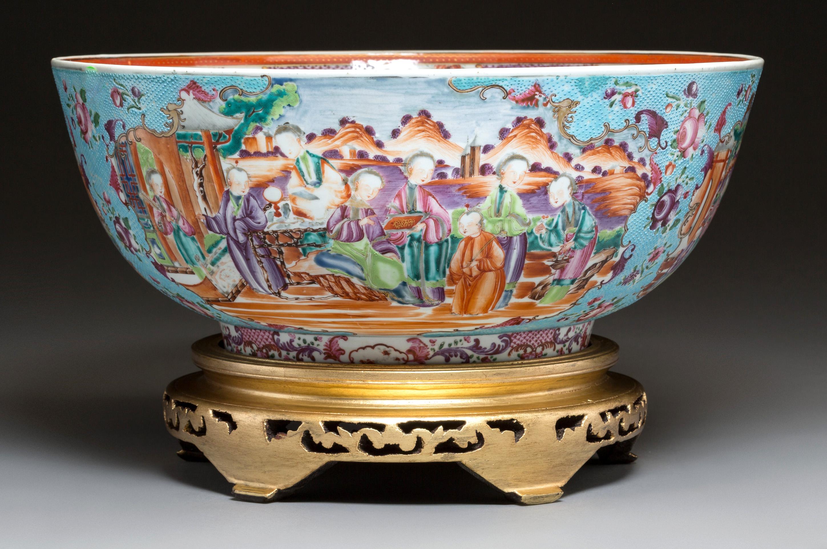 Chinese export porcelain large mandarin punch bowl with turquoise chicken-skin ground,
circa 1785.

The Famille Rose porcelain punch bowl now on a giltwood stand has an unusual turquoise ground with four panels of Chinese figures, two large