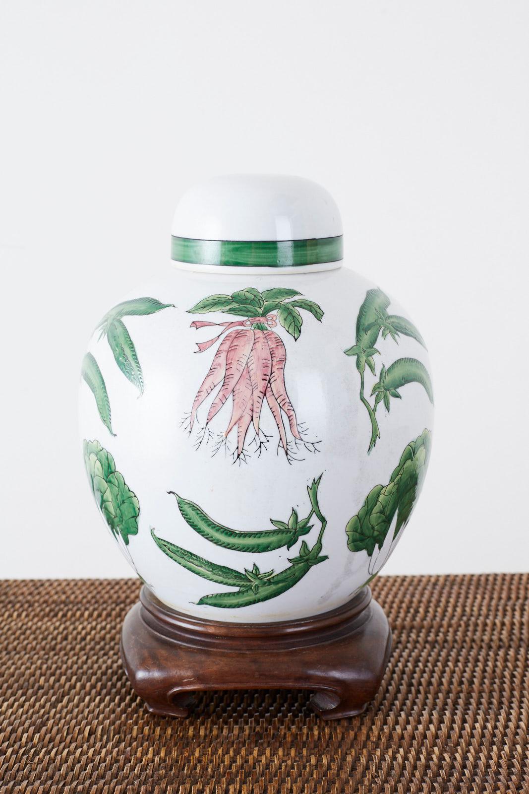 Charming Chinese export porcelain lidded ginger jar on a hardwood stand. Features a highly decorated round form with colorful vegetables over a white ground. The vase with its round lid measures 10 inches high without its stand.