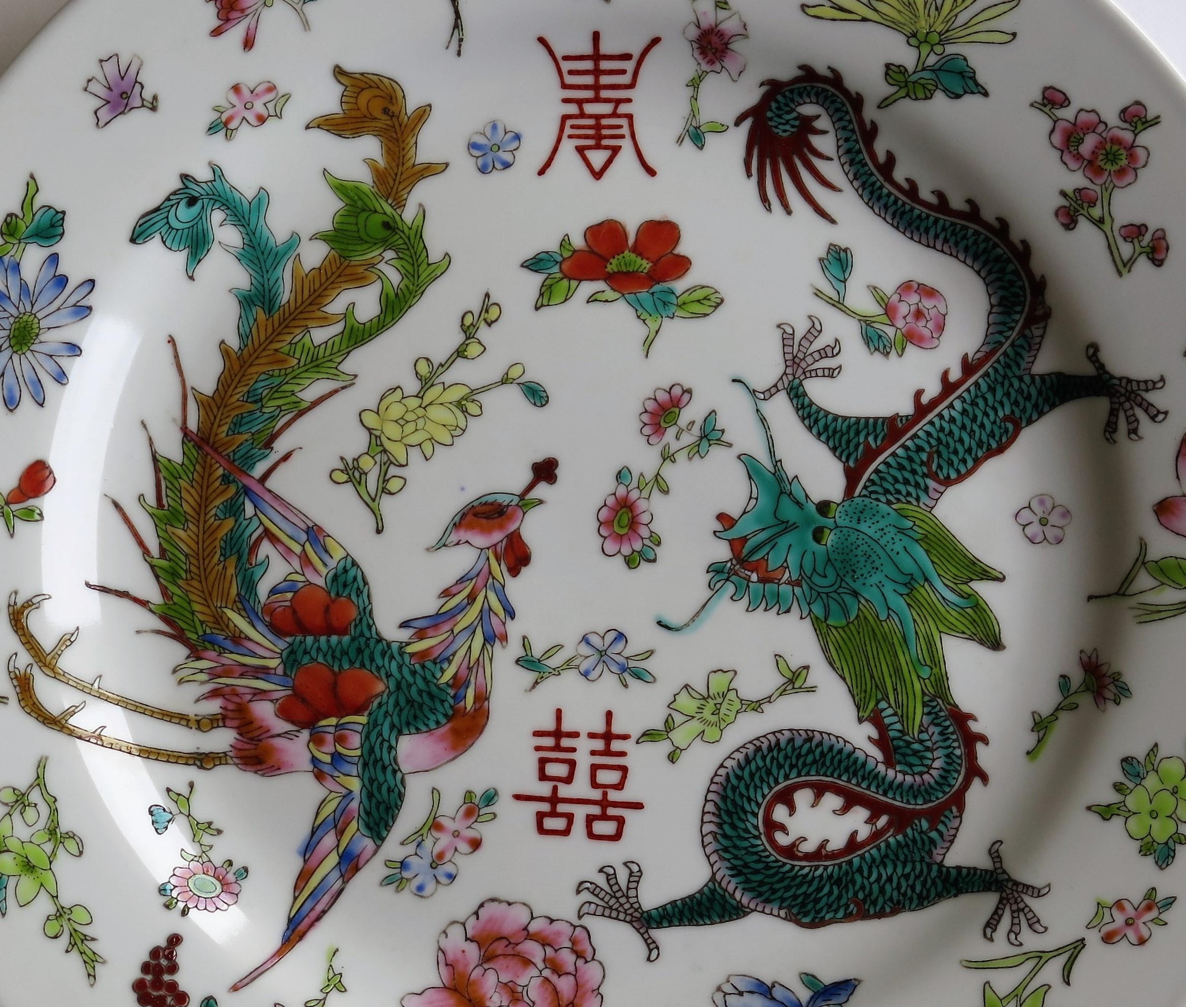 This is a good Chinese export porcelain plate which has been beautifully hand enameled, over-glaze, in very good detail, dating to circa 1950.

The main design is hand painted over-glaze with different colored enamels, depicting a 5-toed Dragon