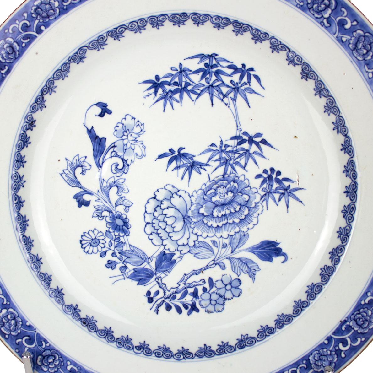 A Chinese porcelain plate, Qing Dynasty (1644-1912), Qianlong Period (1736-1795), East India Company. Underglaze blue decoration depicting in the centre a garden with several type of flowers and ruyi scrolls on the inside frieze. The rim presents