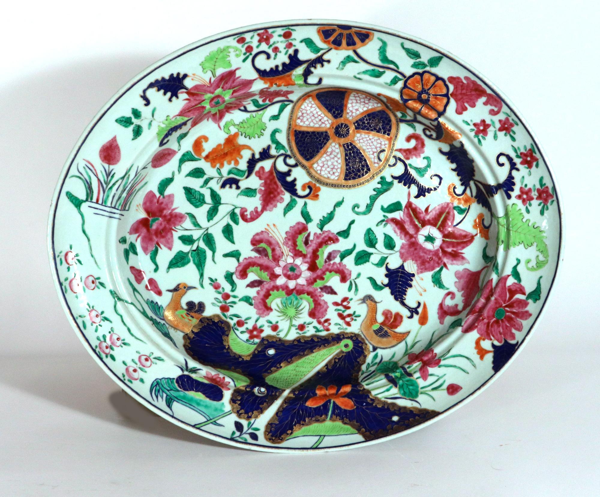 Chinese Export Porcelain Pseudo Tobacco Leaf Large Dish and Drainer,
Circa 1765-75

The oval Chinese Export deep dish is fully painted with a variation of the Tobacco Leaf pattern with two Mandarin ducks amongst foliage and on either side of a blue