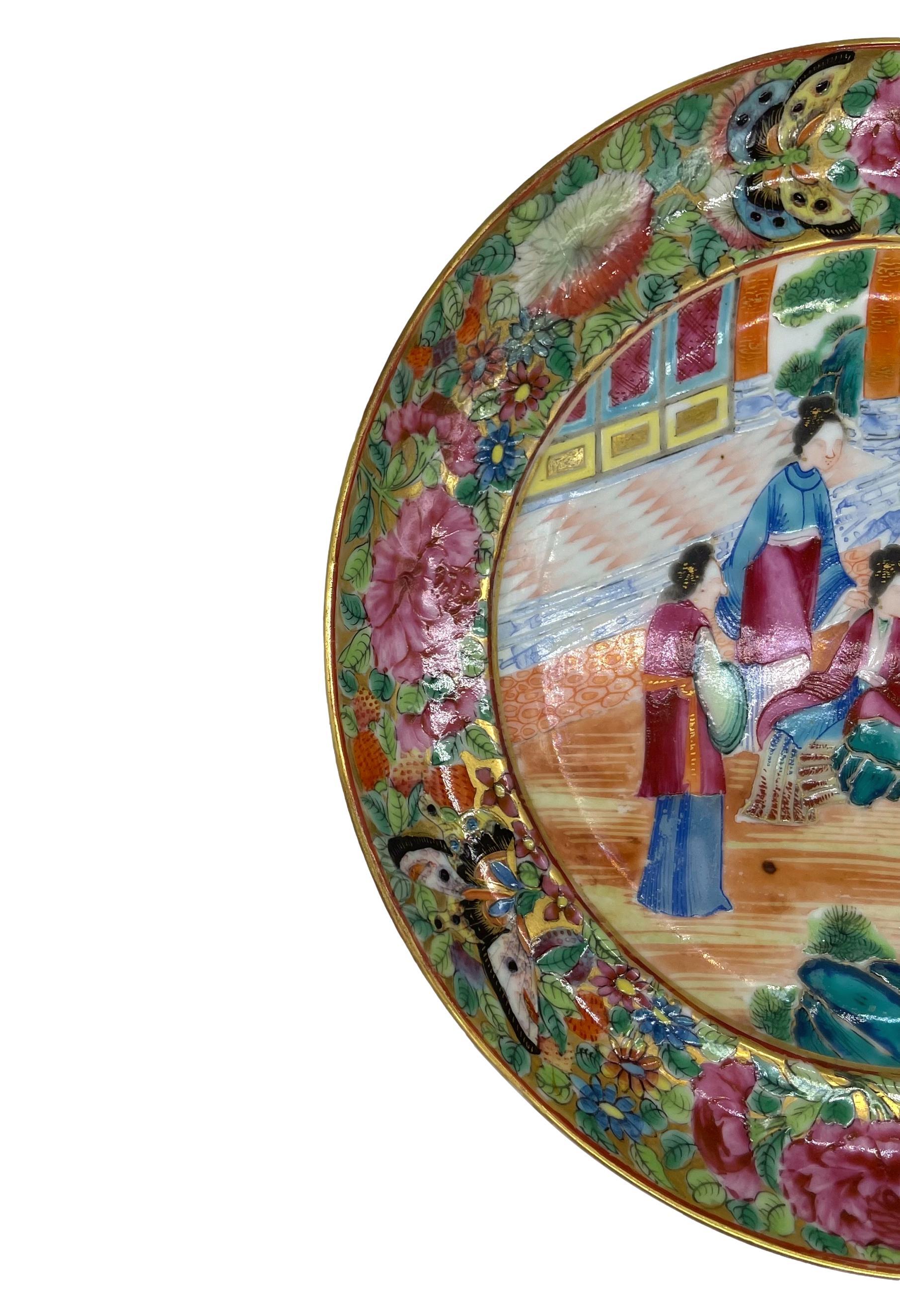 Chinese Export Porcelain Rose Mandarin plate, ca. 1840, with a central design depicting a pavilion scene with six figures at a Wei Qi board, with hyper-vivid enamels and fine gilt accents, with multi-layered raised polychrome enamels, with blue