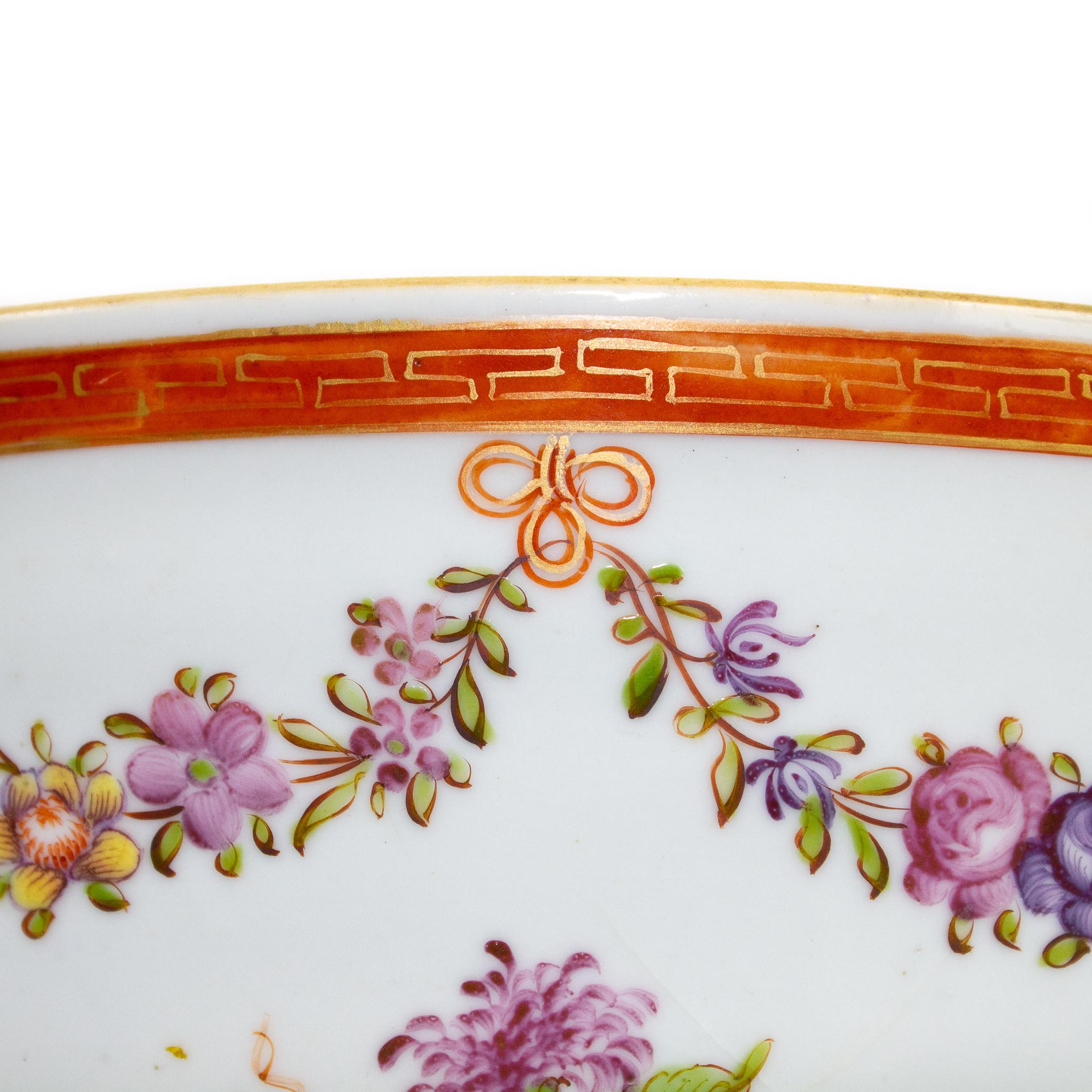 A Chinese Porcelain rounded bowl, India East Company, Qing Dynasty (1644-1912), Qianlong period (1736-1795). Inside, the bowl displays in the centre, a peony and a lotus flower. On the outside, under a frieze with a gilt geometric pattern, it's