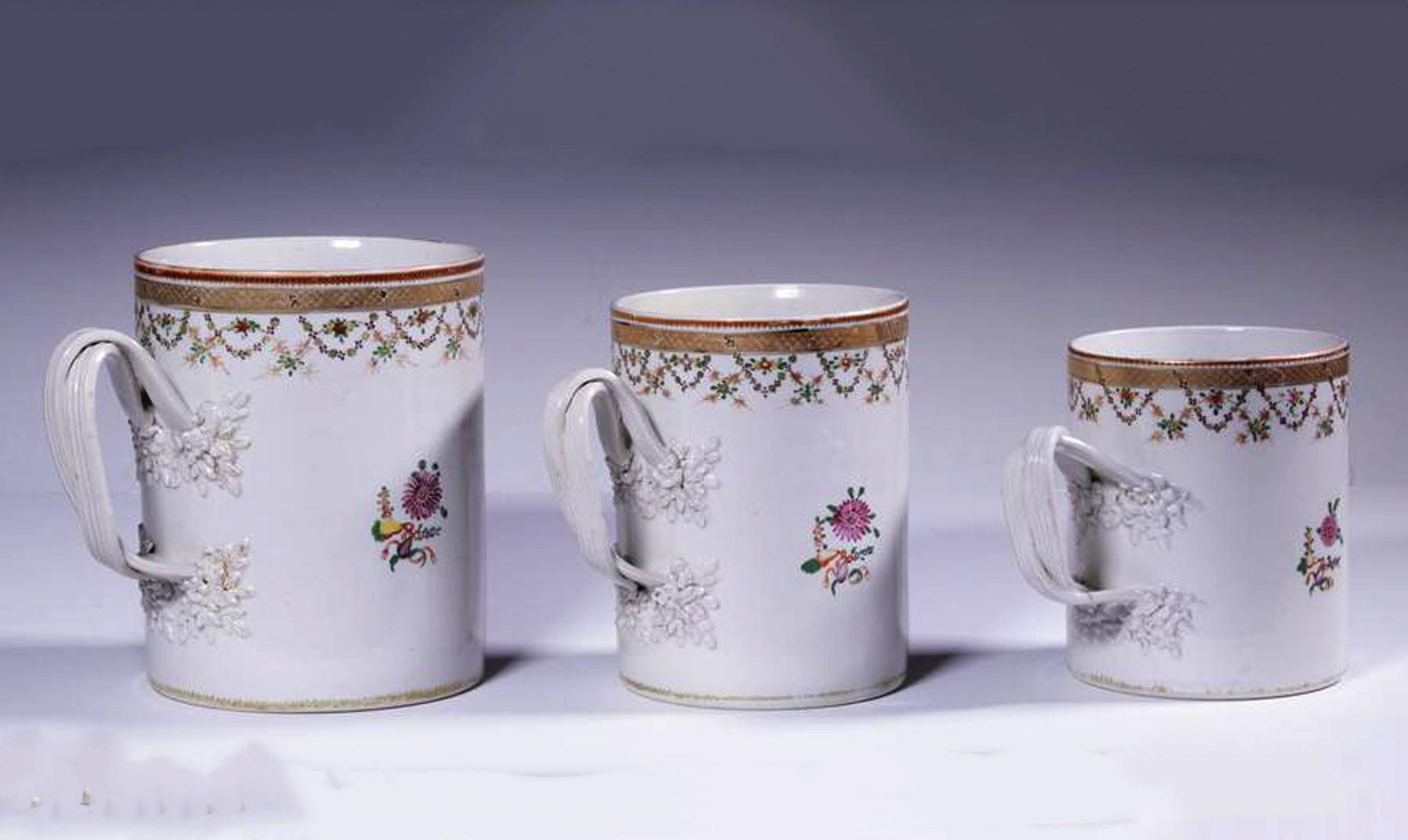 Chinese export porcelain set of graduated famille rose mugs or tankards,
Circa 1780

The Chinese Export porcelain tankards or mugs are each enameled with a neoclassic urn design with flowers within a think green enamel circular circle. The rim