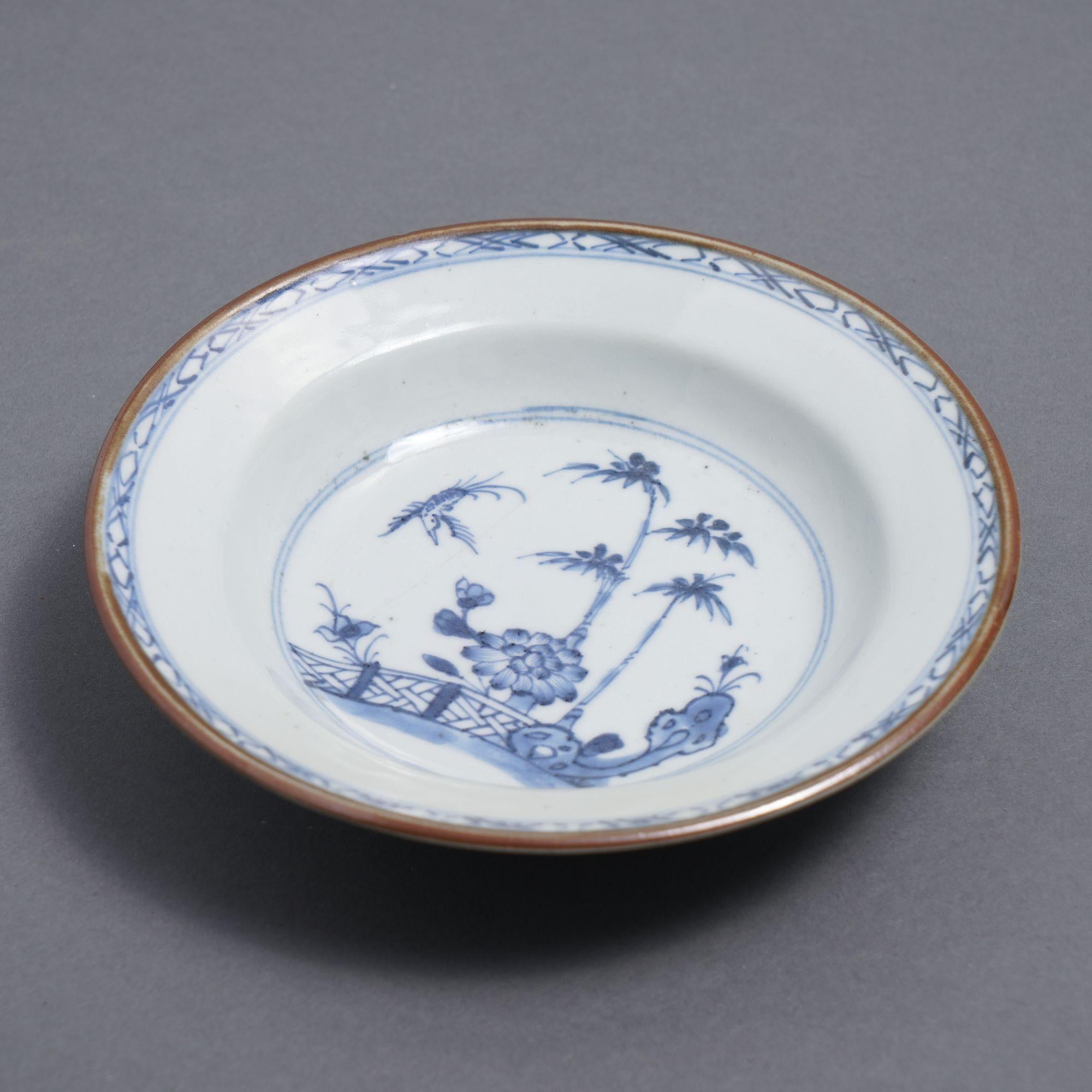 Chinese export porcelain dish decorated in a cobalt under glaze blue narrow rim band and fenced landscape within a double cobalt circle at the base of the dish.

China, circa 1800.