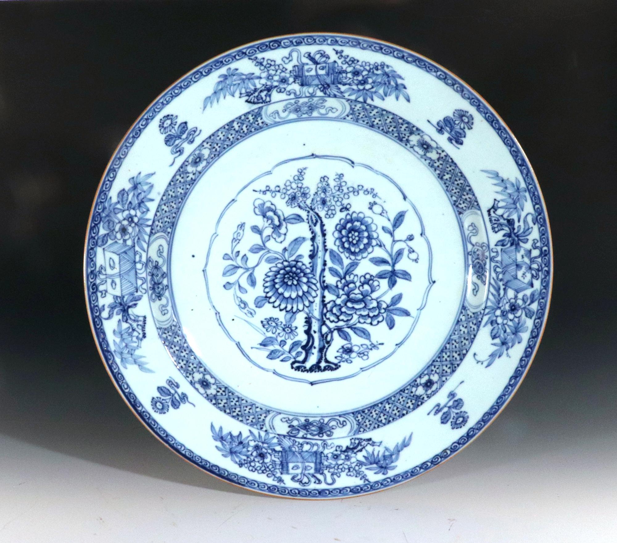 Chinese Export Porcelain Underglaze Blue Botanical Circular Dish,
Circa 1775

This Chinese Export circular dish exemplifies the underglaze blue and white technique popular during the 18th century. The central well features a captivating botanical