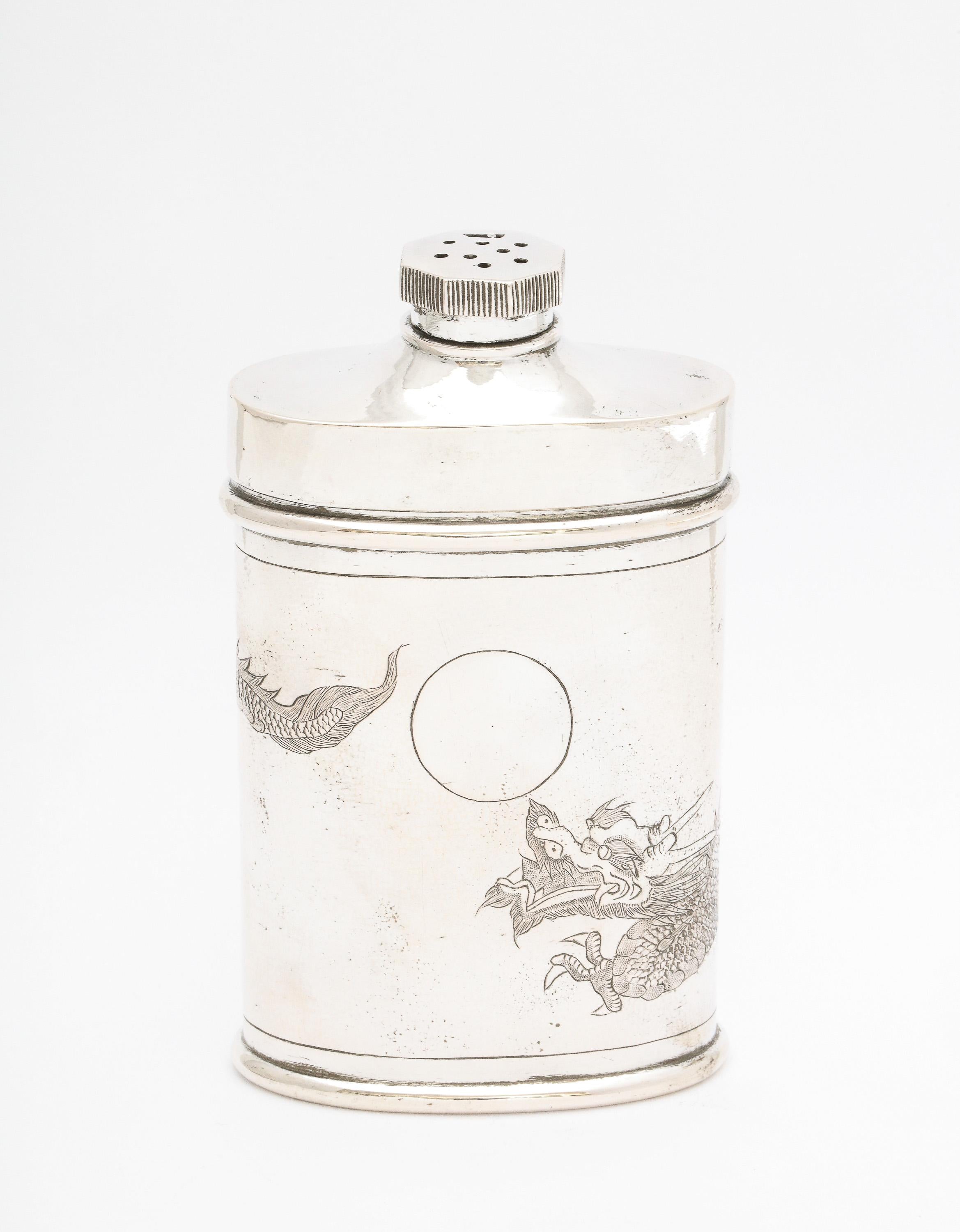 Chinese Export, sterling silver powder/talc holder/shaker, China, Ca. 1900. Decorated with an etched, full dragon that wraps itself around the holder/shaker. Holder is also lightly hammered in design. Vacant cartouche. Closure mechanism on cap/lid