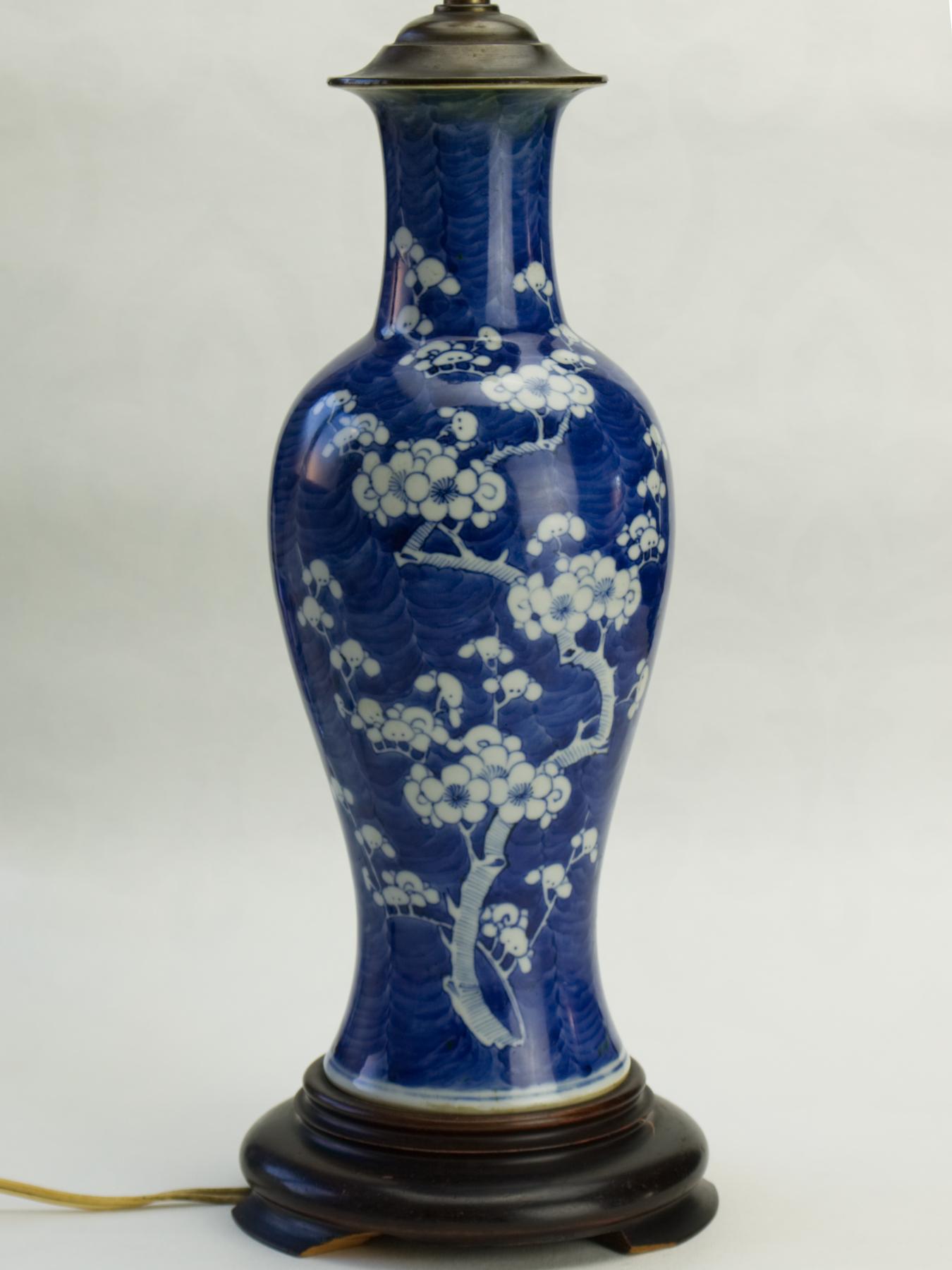 Une grande lampe à vase en porcelaine bleu et blanc en forme de prunus, sur une base en bois. Pas de cheveux, pas de restauration. La hauteur du vase est d'environ 25 cm. Traces d'utilisation et de vieillissement. Le vase seul mesure 34cm / 13.34 in