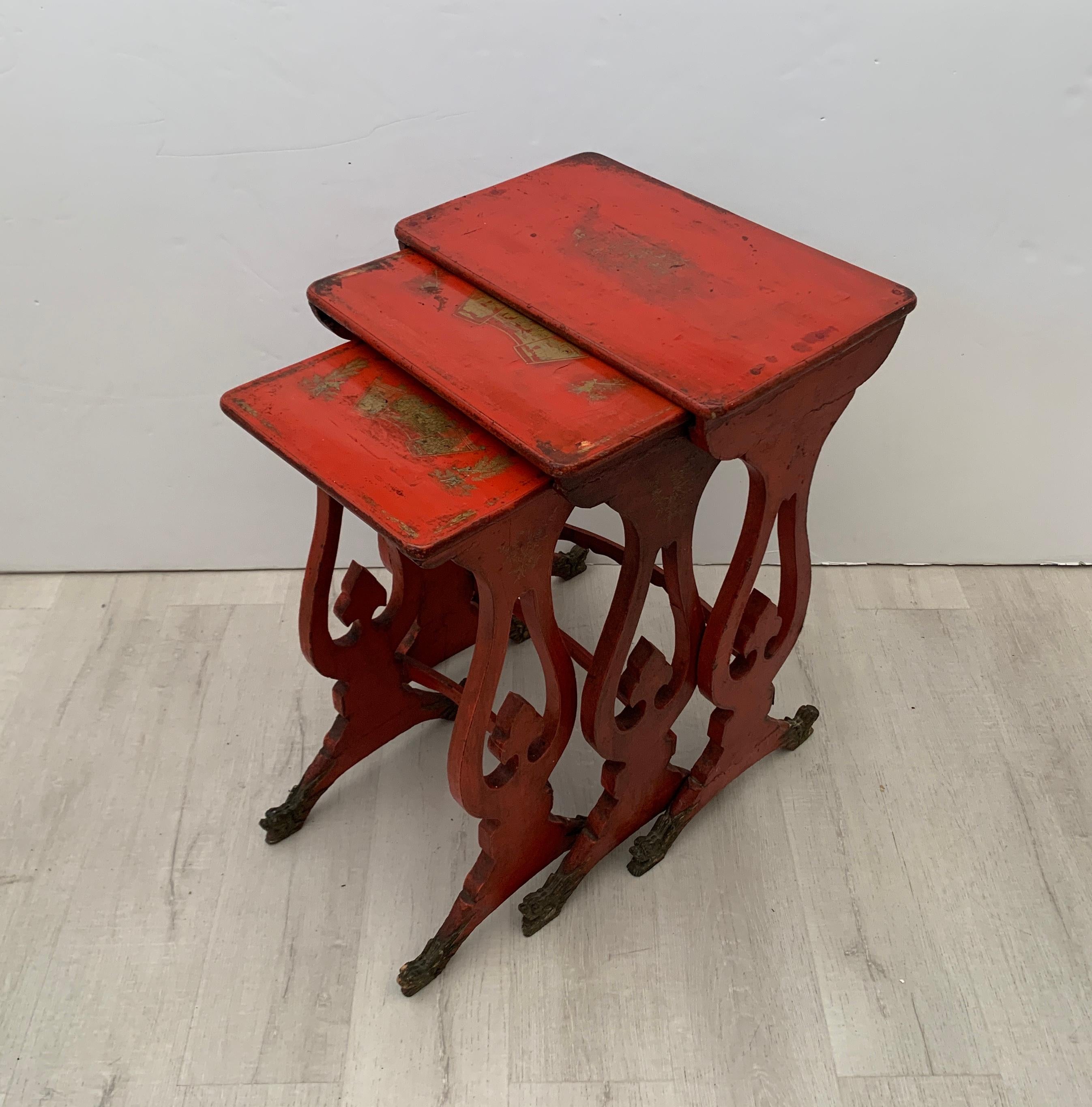 A charming set of three Chinese export nesting tables in red lacquer with gilt painted designs and carved dragon feet, late 19th century, China. 

The nest of three tables elegantly proportioned, with lyre-form legs terminating in carved dragon