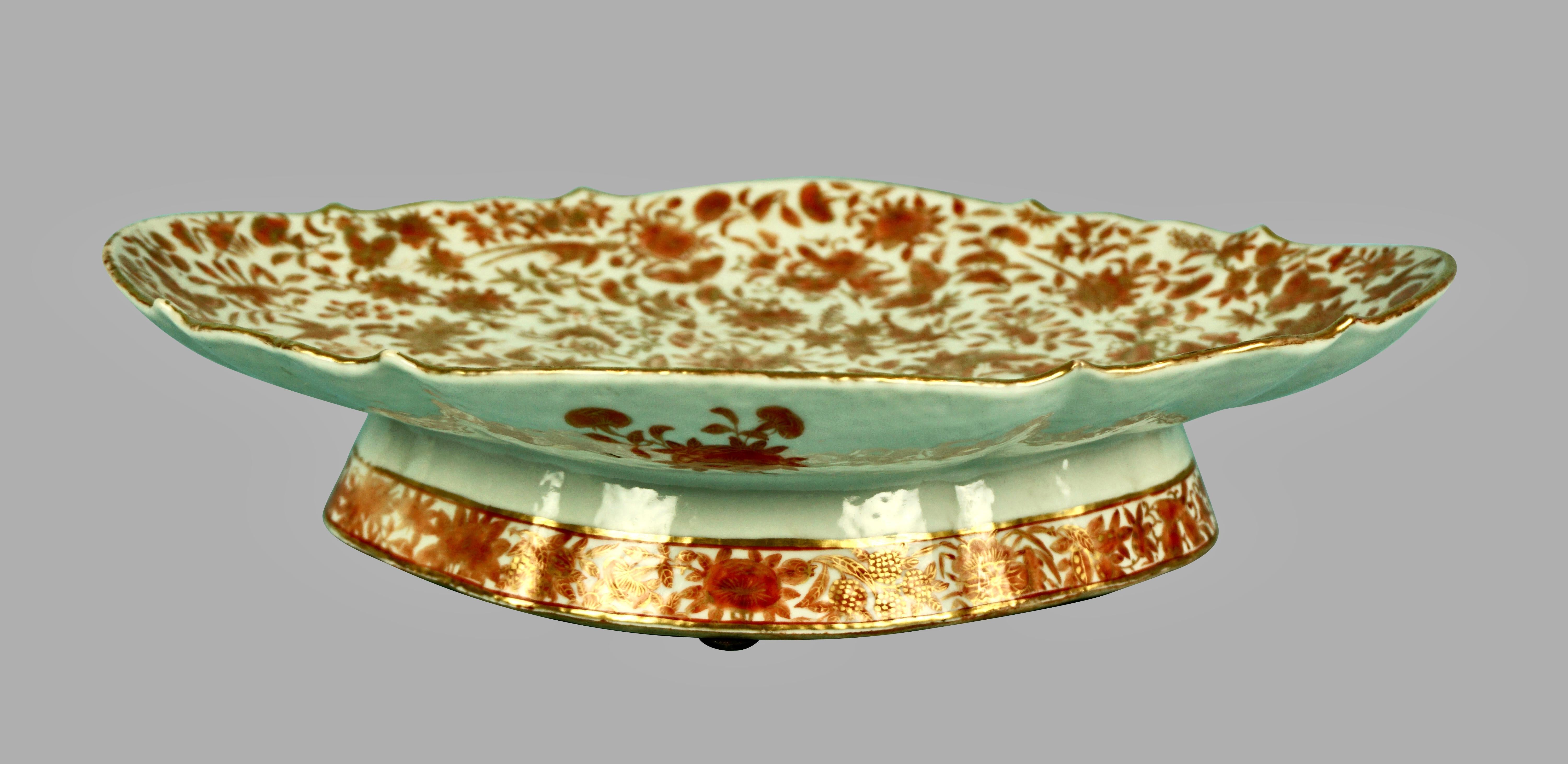 An impressive Chinese export sacred bird and butterfly pattern centerpiece decorated overall in typical orange and brown palette, with gilt-outlined birds, butterflies and flowers. Offered with a covered vegetable dish of the same pattern and