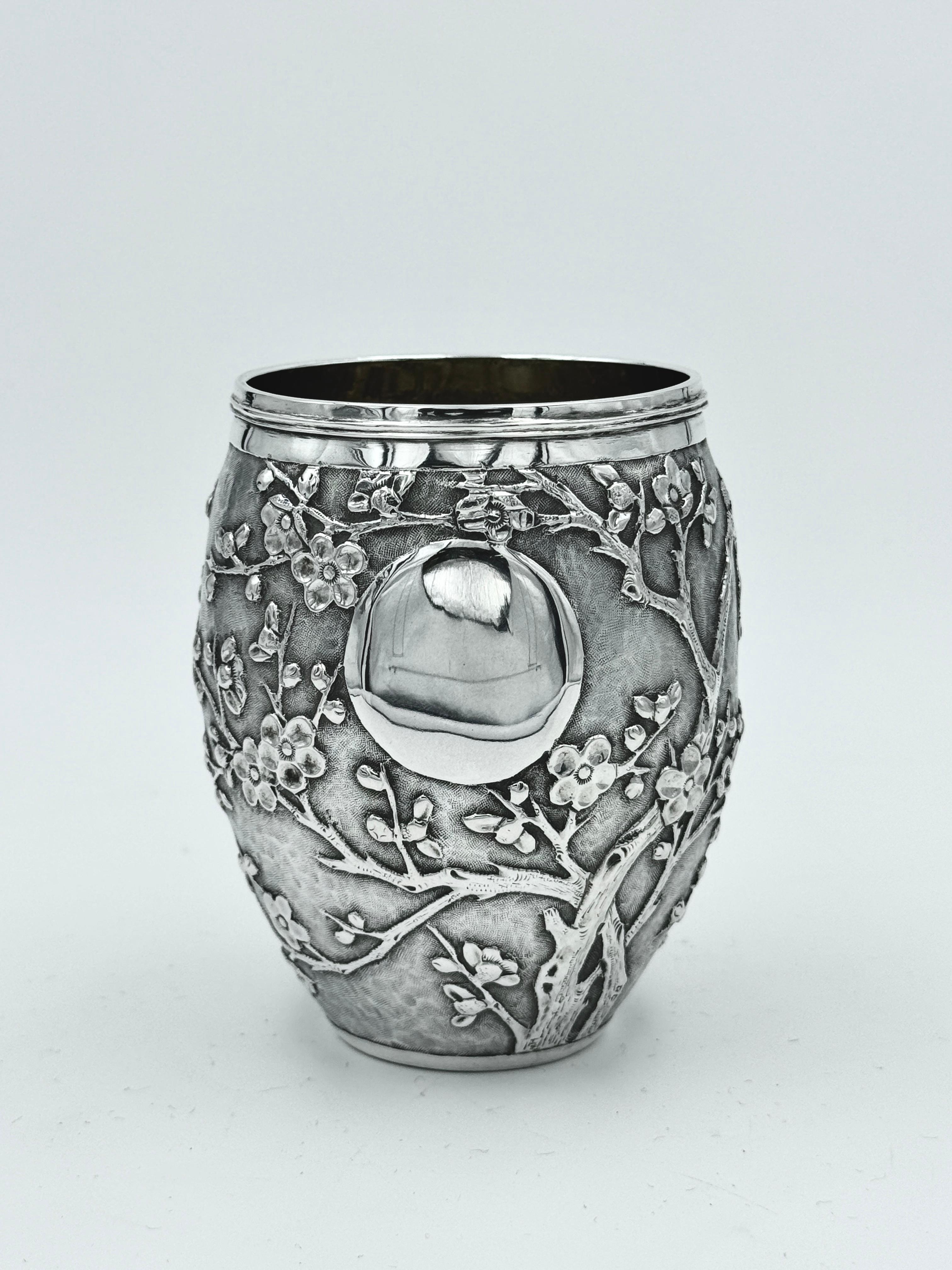 Becher aus chinesischem Exportsilber, um 1900, geprägt und ziseliert mit einer Prunusblüte auf mattem Hintergrund, mit einer einzelnen runden, freien Kartusche. Der tonnenförmige Becher ist mit TC für Tuck Chang, einen Einzelhändler in Shanghai, und