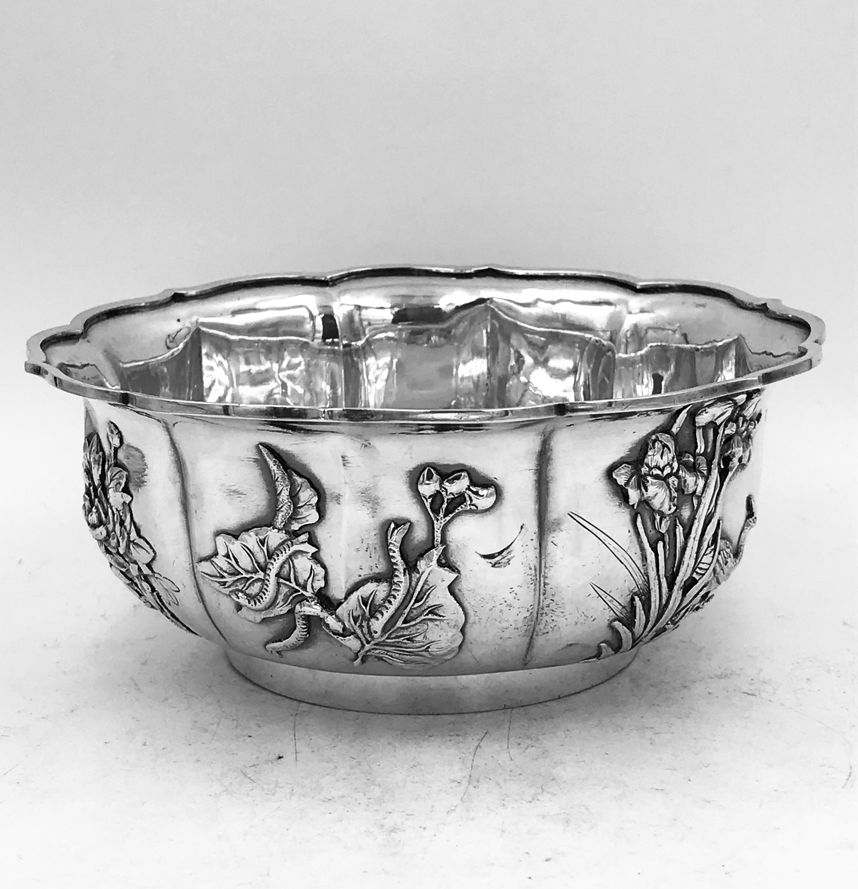 A Chinese silver bowl of lobed round form with applied decoration depicting various flowers and birds. It has the mark of TS for the shop of Tien Shing or Tin Sang, which was based in Hong Kong in the late 19th century. This bowl dates from circa