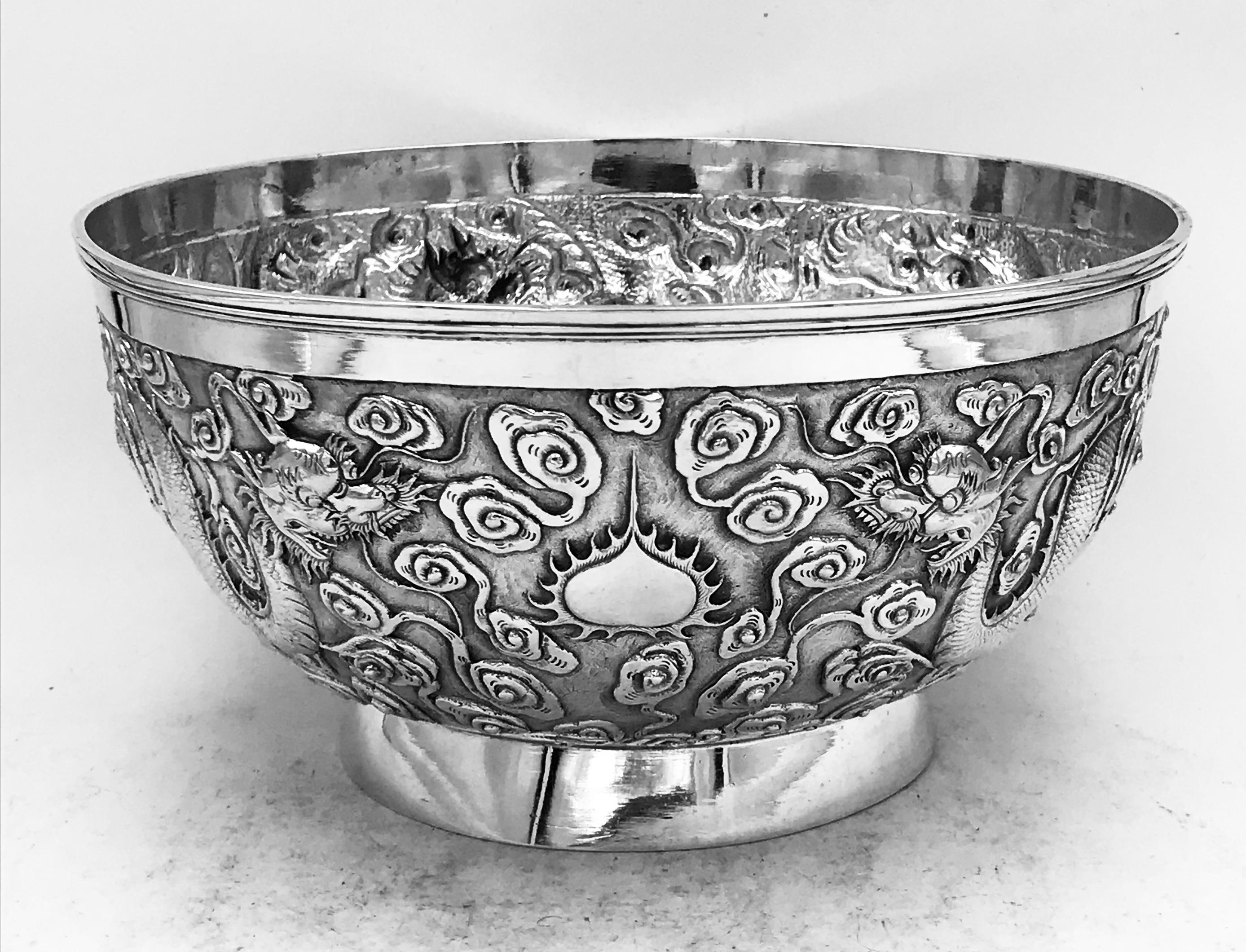 A Chinese export silver bowl, profusely decorated with dragons among clouds on a matte background. The bowl has a vacant cartouche, and is from Shanghai (上海) circa 1890. Marked by the maker '雄甡‘ (XiongShen), and the retailer 'Luen Wo' (联和).
