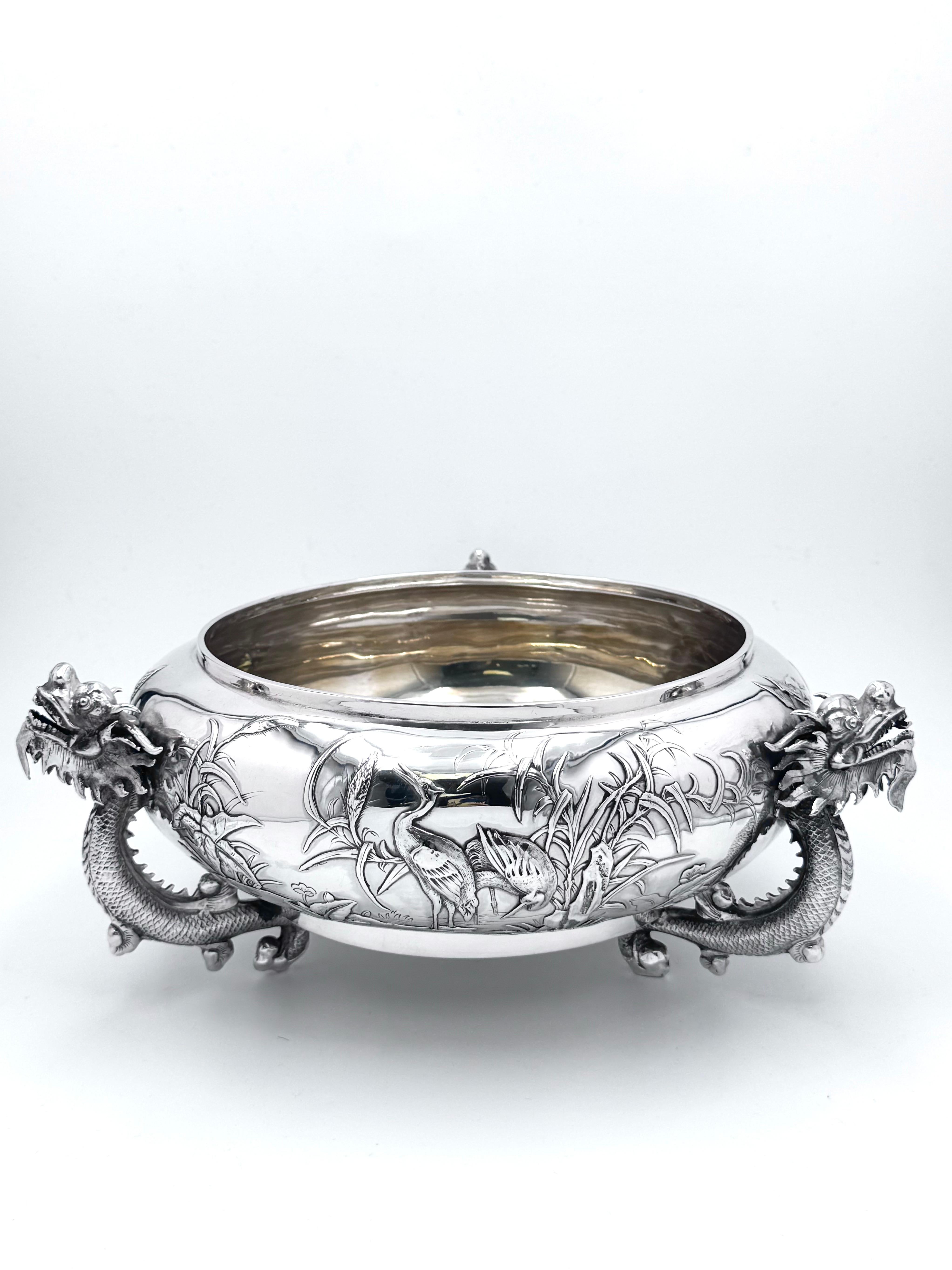 Cuenco chino de plata de exportación con decoración aplicada que representa diversas plantas y aves, y con tres asas de dragón. La marca del minorista es WH, de Wang Hing, el cuenco data de alrededor de 1890, y el fabricante es 协昌 (Xie Chang). Peso