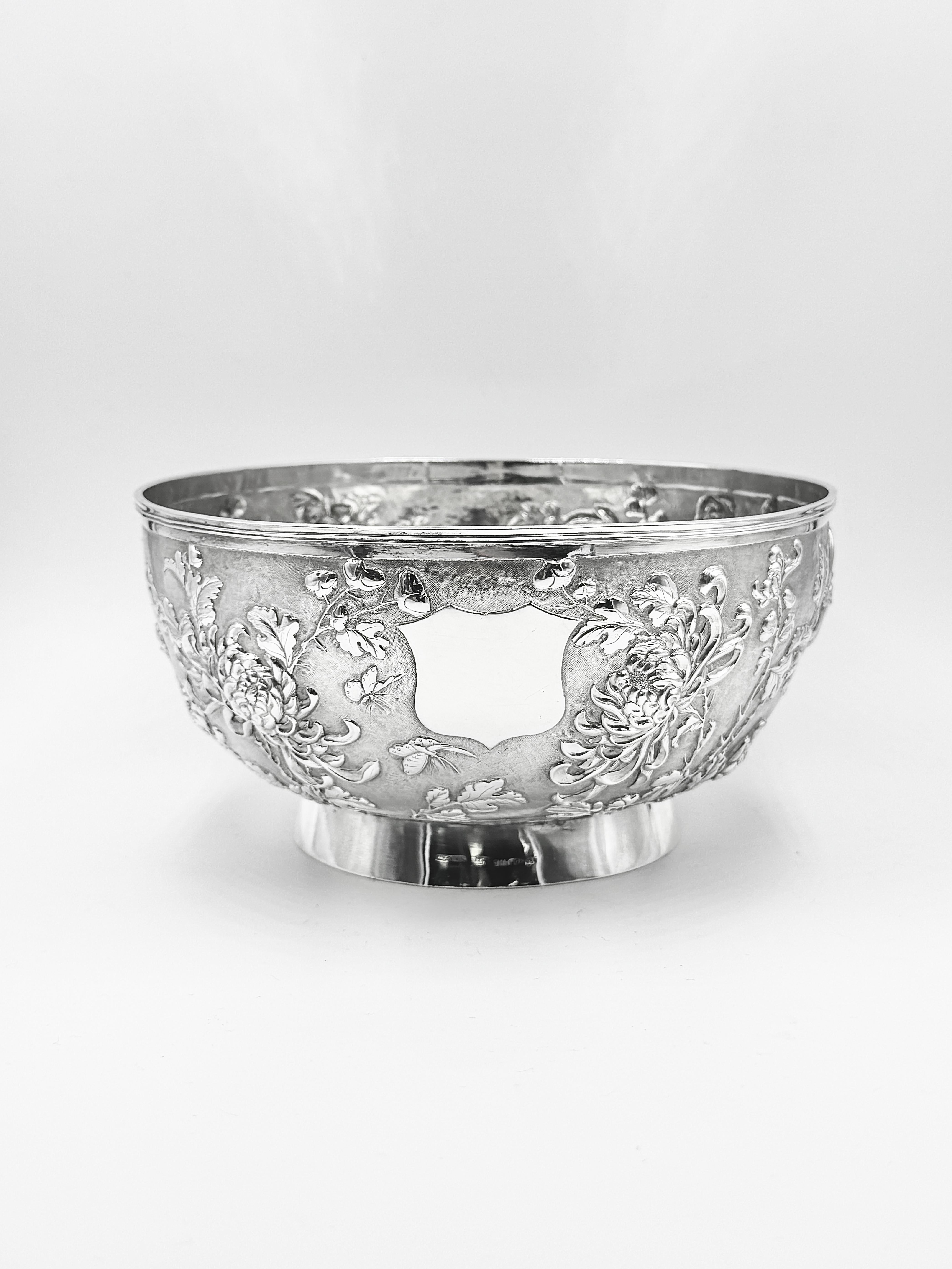 Bol en argent d'exportation chinois vers 1895, finement décoré de chrysanthèmes sur un fond mat,  entrecoupés de six papillons en vol. Il comporte un seul cartouche vacant en forme d'écu. Vendue par Wo Shing de Shanghai et fabriquée par Zan Ji (赞记),