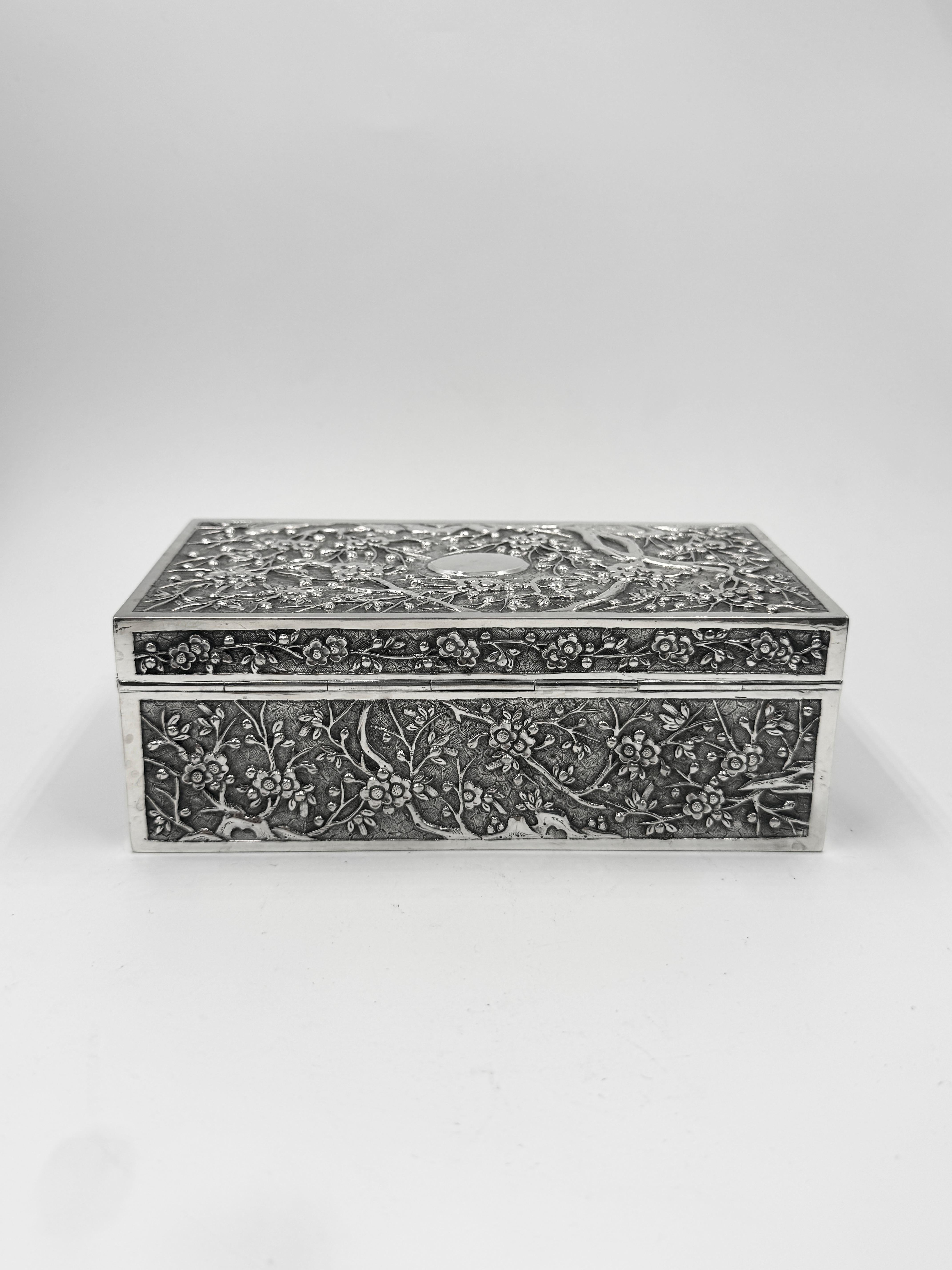 Chinese Export Silver Table Box of rectangular shape, embossed and chased with prunus decoration on a 