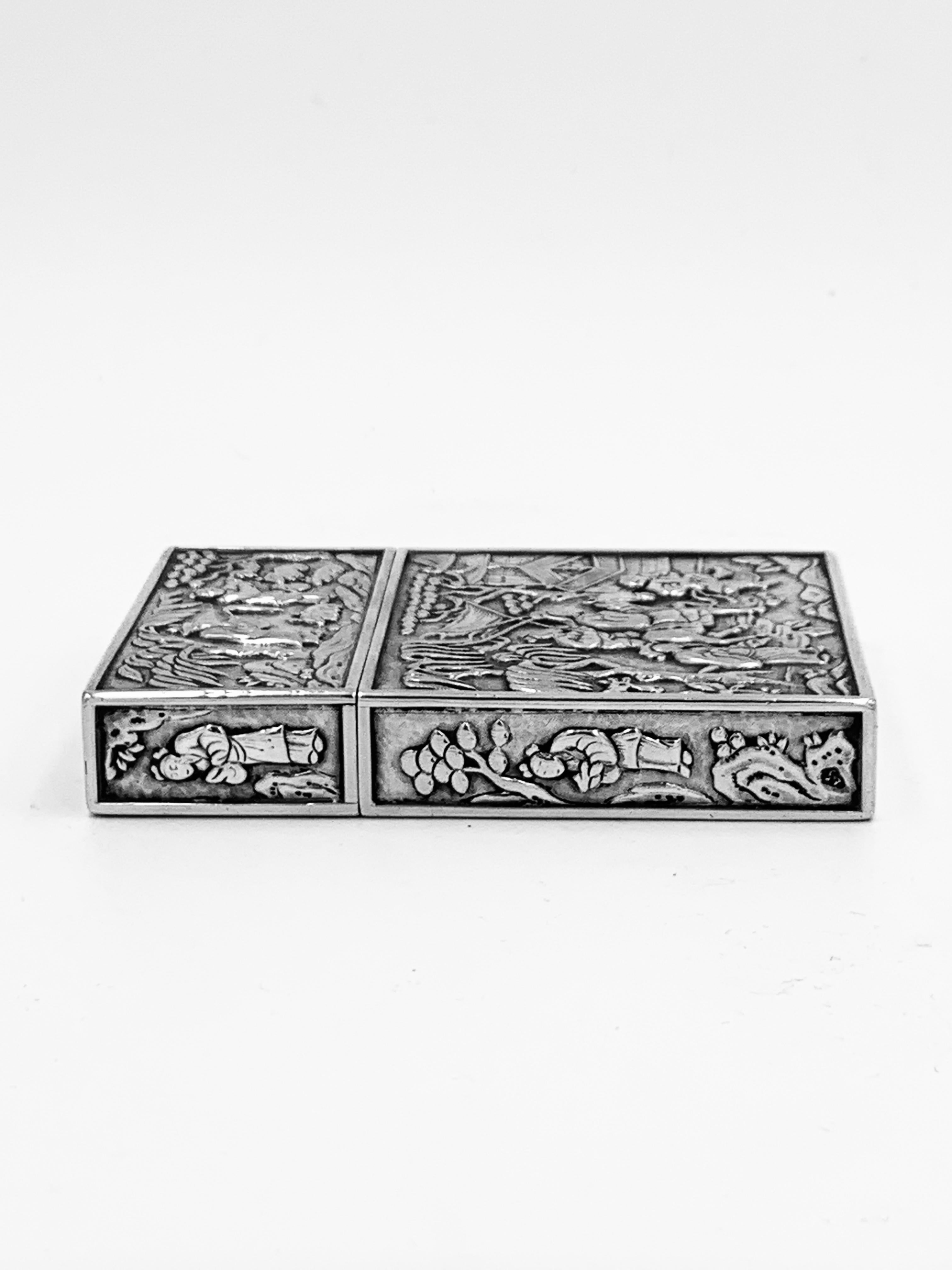 A Chinese Export Silver Card Case embossed and chased with figural scenes on a matte background, including playing Go and horse-riding. The top has a plain oval cartouche. It was retailed by the firm of Wong Shing, Canton c1835. Wong Shing was a