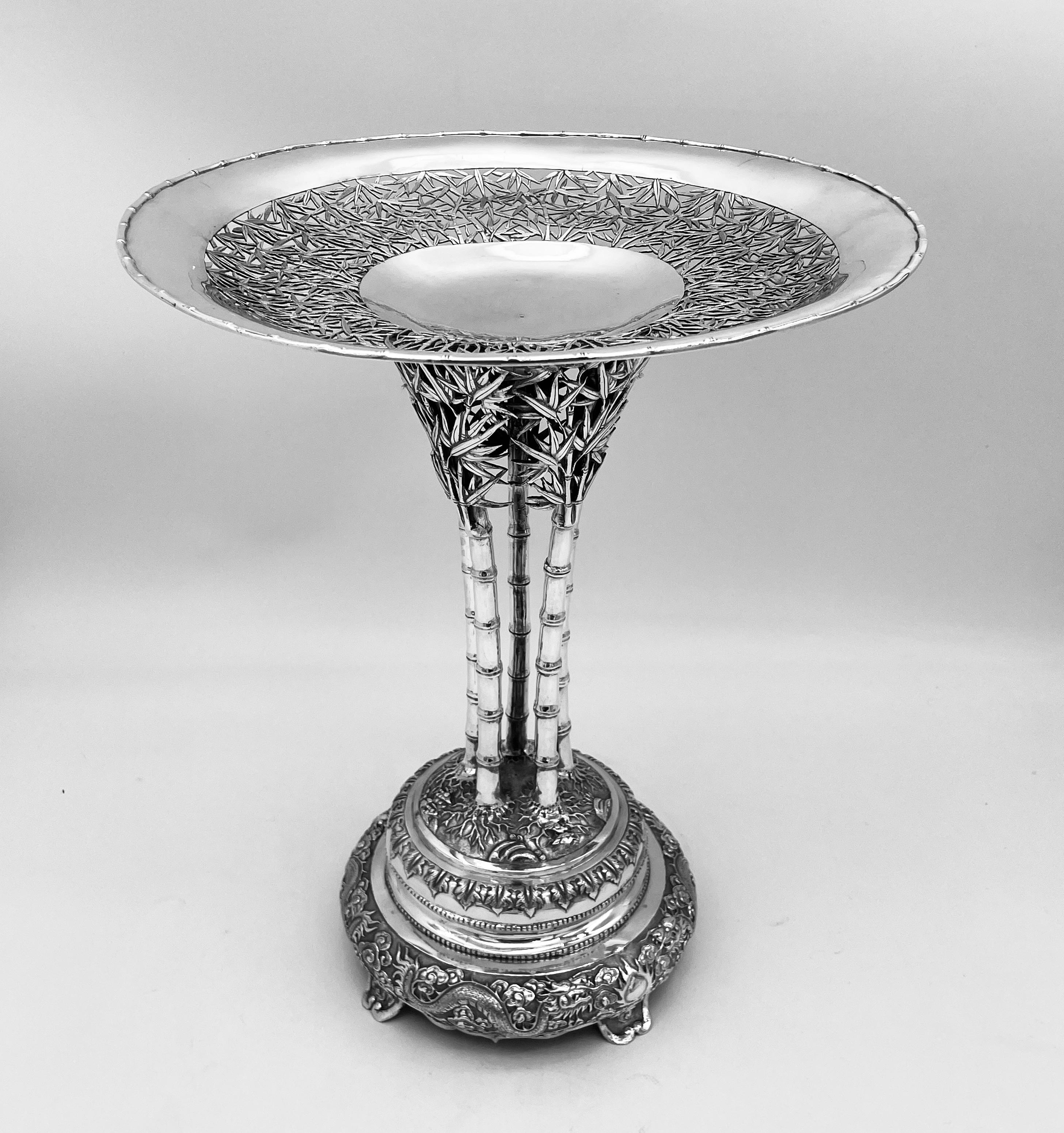 This impressive Chinese Export Silver Centrepiece,  consists of a large central dish, pierced with bamboo decoration, supported by five shoots of bamboo also with bamboo leaf decoration. The base which rests on four feet, has two pairs of opposing