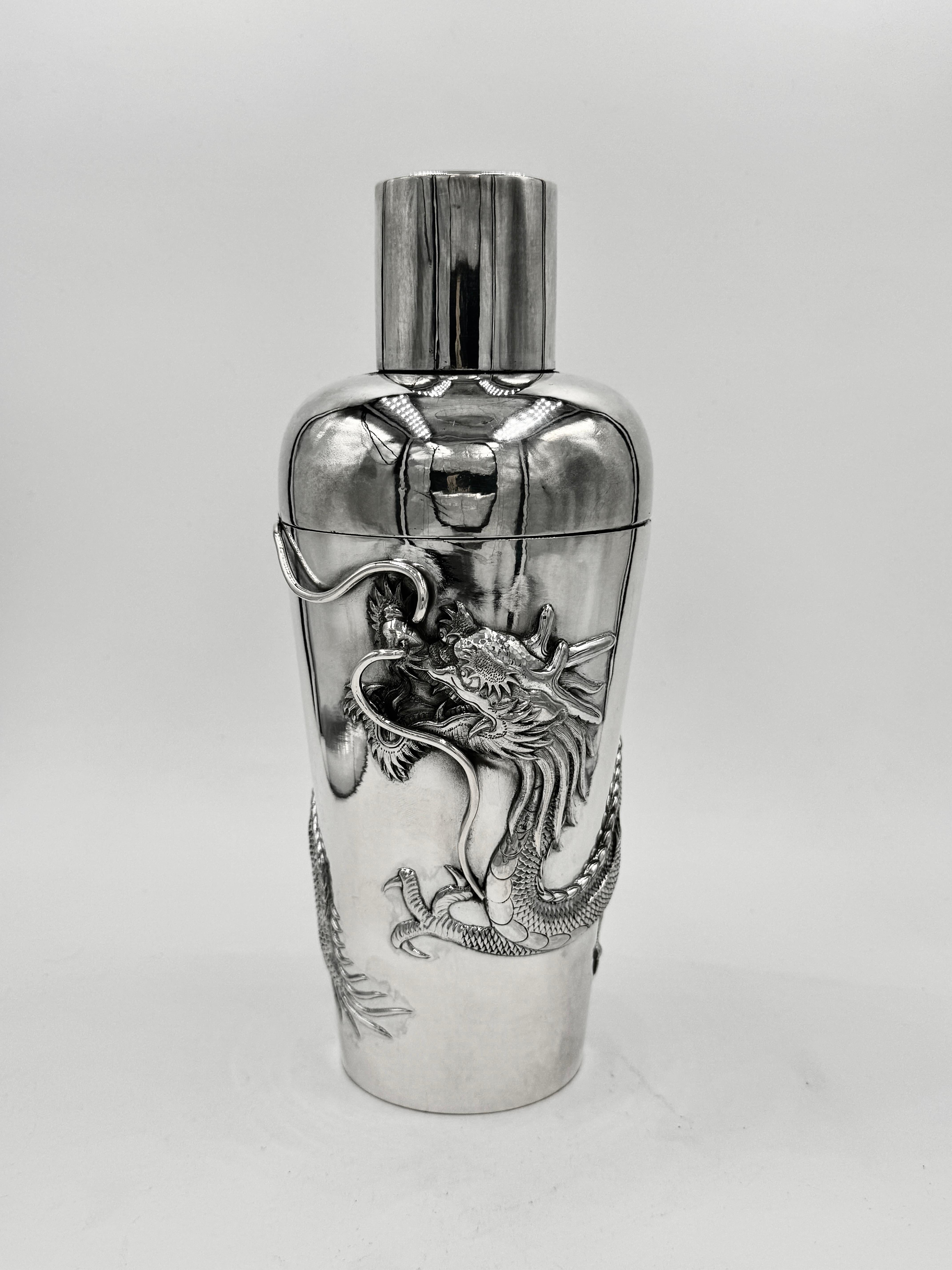 Shaker à cocktail en argent d'exportation chinois, vers 1925, estampé et ciselé avec un décor de dragon Retaillé par Hung Chong, et fabriqué par Sheng (声). 
Un dragon unique et audacieux, dont le museau est parcouru de vrilles saillantes, s'enroule