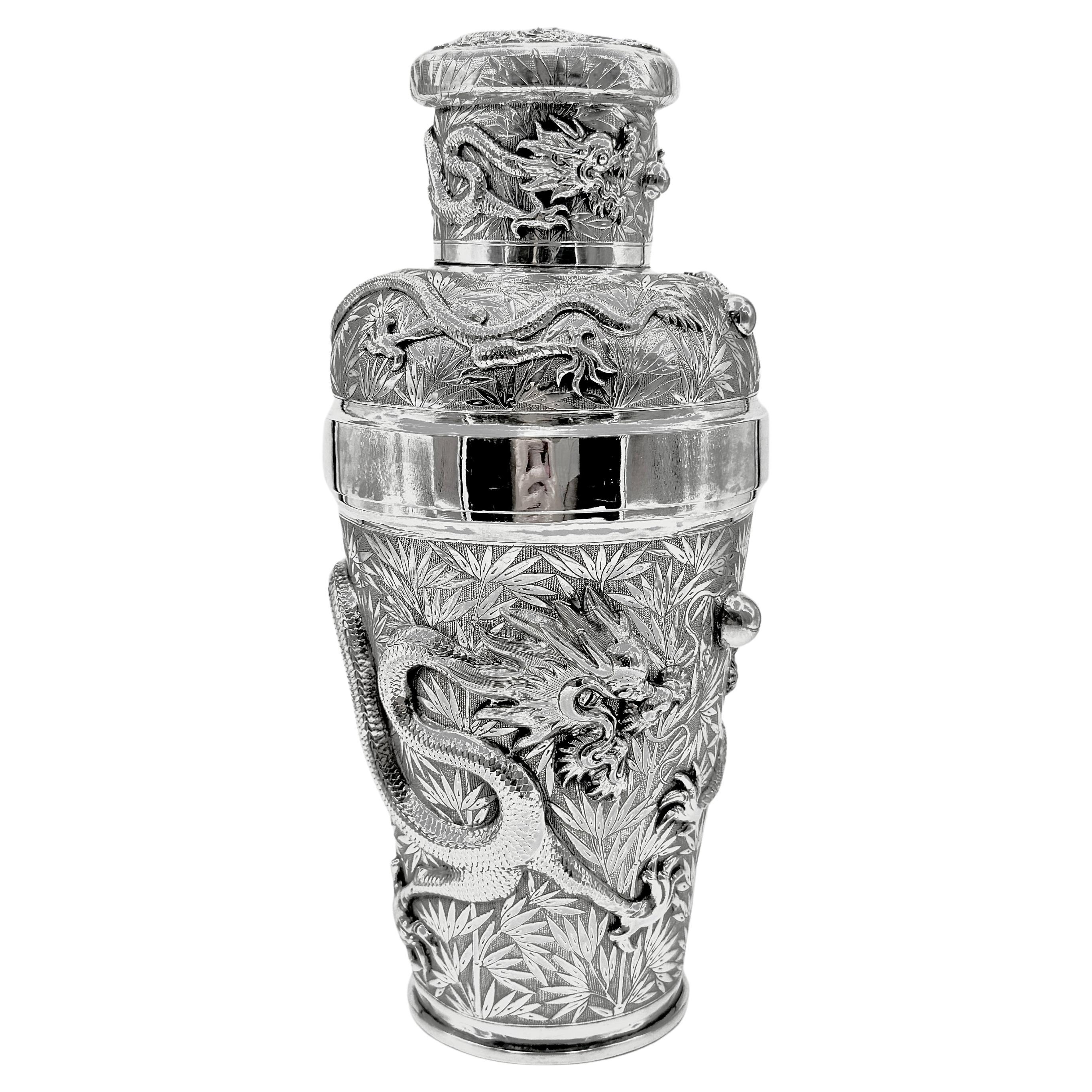 Coctelera china de plata de exportación, fabricada por Tu Mao Xing (涂茂興) en Jiujiang (九江), hacia 1930. Finamente repujado y cincelado en altorrelieve con dos dragones opuestos que persiguen una perla en el cuerpo, otro dragón enroscado alrededor de