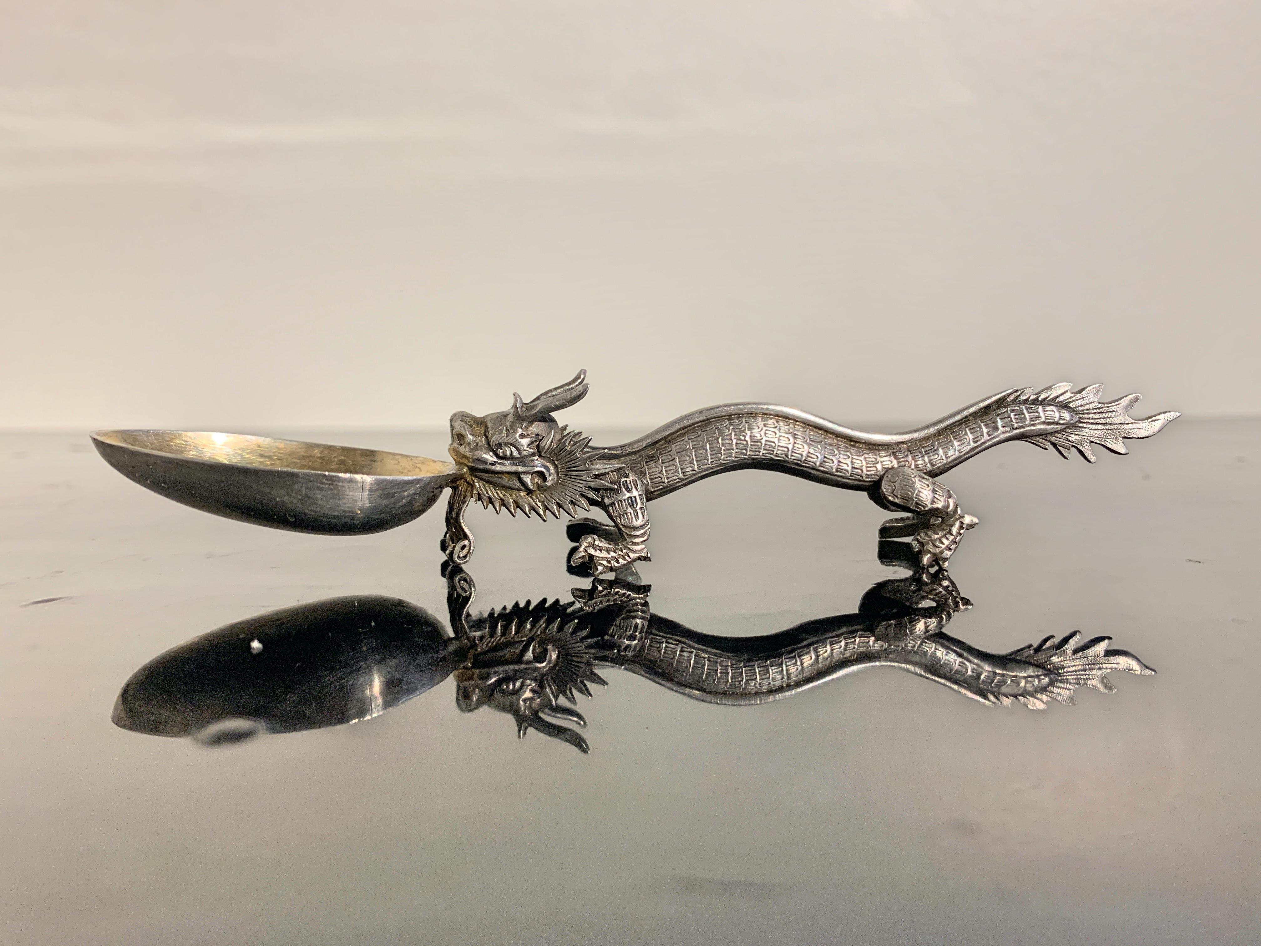A very fine and charming Chinese export silver spoon in the form of a dragon, by Wang Hing & Co., Qing Dynasty, late 19th century, China.

The small spoon masterfully designed with the handle in the form of a prancing dragon holding the gilt bowl