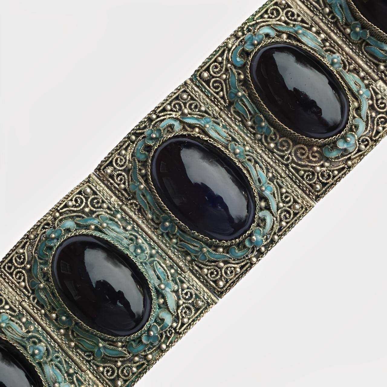 Exquisito brazalete chino de exportación de filigrana de plata canetille, con esmalte azul y piedras de ónice negro (no probadas). Hemos limpiado ligeramente la pulsera. Aún conserva la etiqueta original. Falta un pequeño trozo de esmalte, por