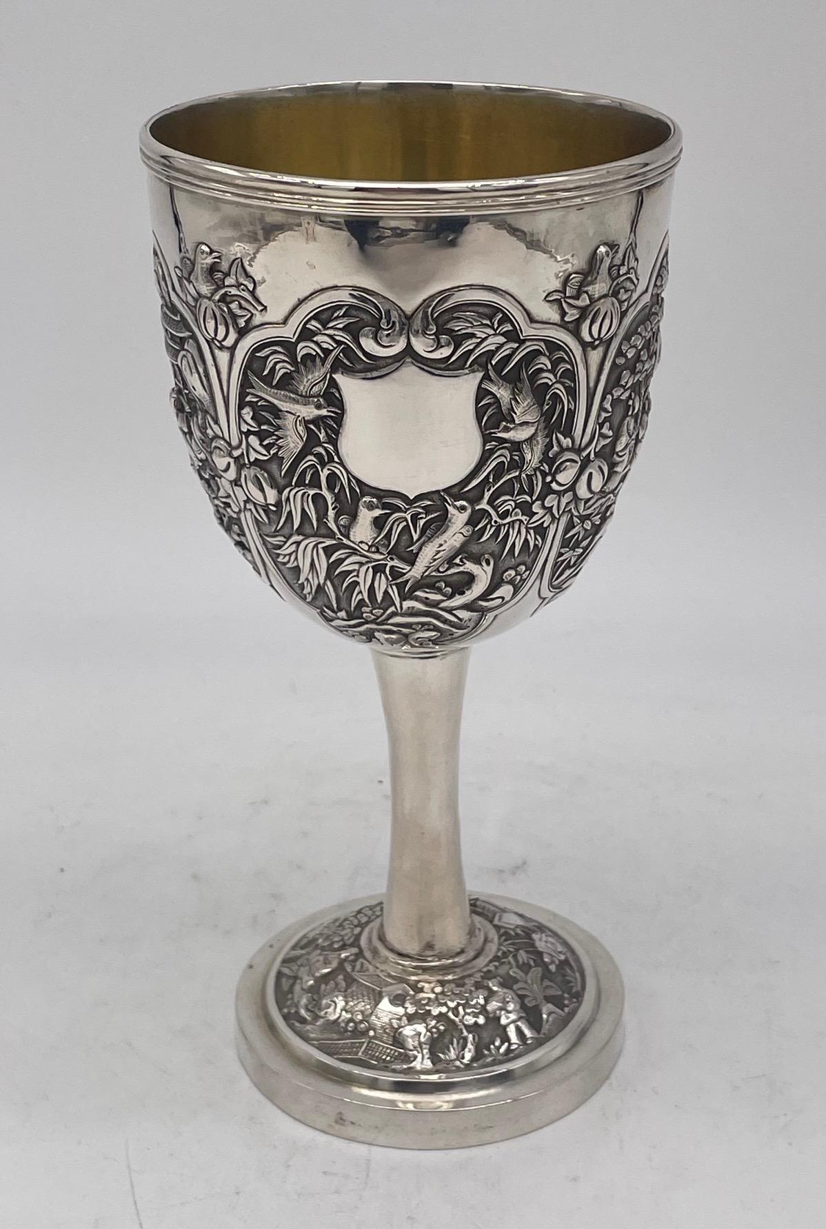 A Chinese Export Silver Goblet of rare and unusual form. The bowl has four panels, two decorated with figural scenes; a third with mythical beasts; and the fourth, which also has a vacant shield shaped cartouche, three birds amongst foliage.
The