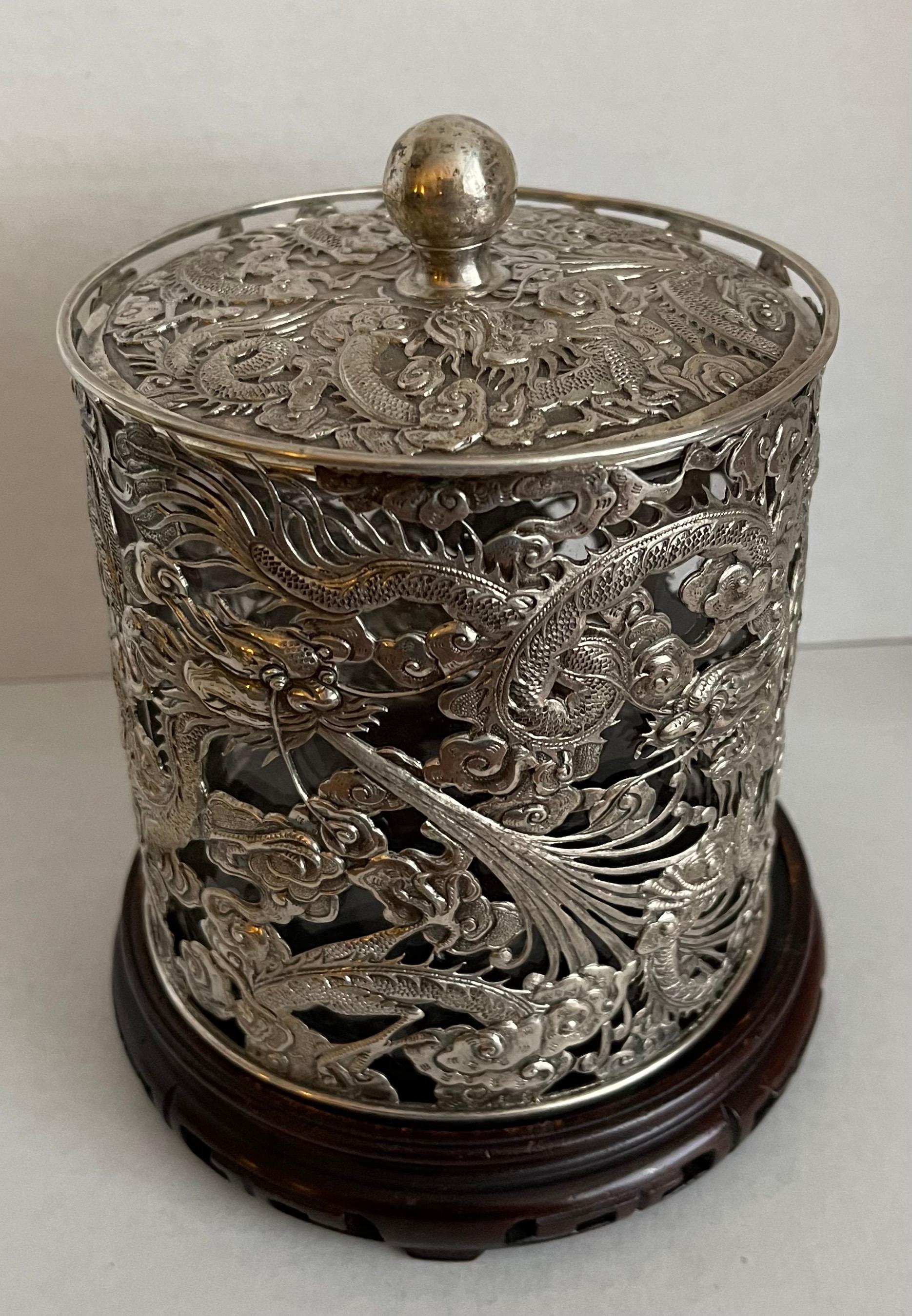 Unusual Chinese Export silver and glass humidor. 
Silver with repoussè and engraved dragon motif. clear glass liner is believed to be original. Illegible 
makers mark on the inside of the lid, as shown in photos.