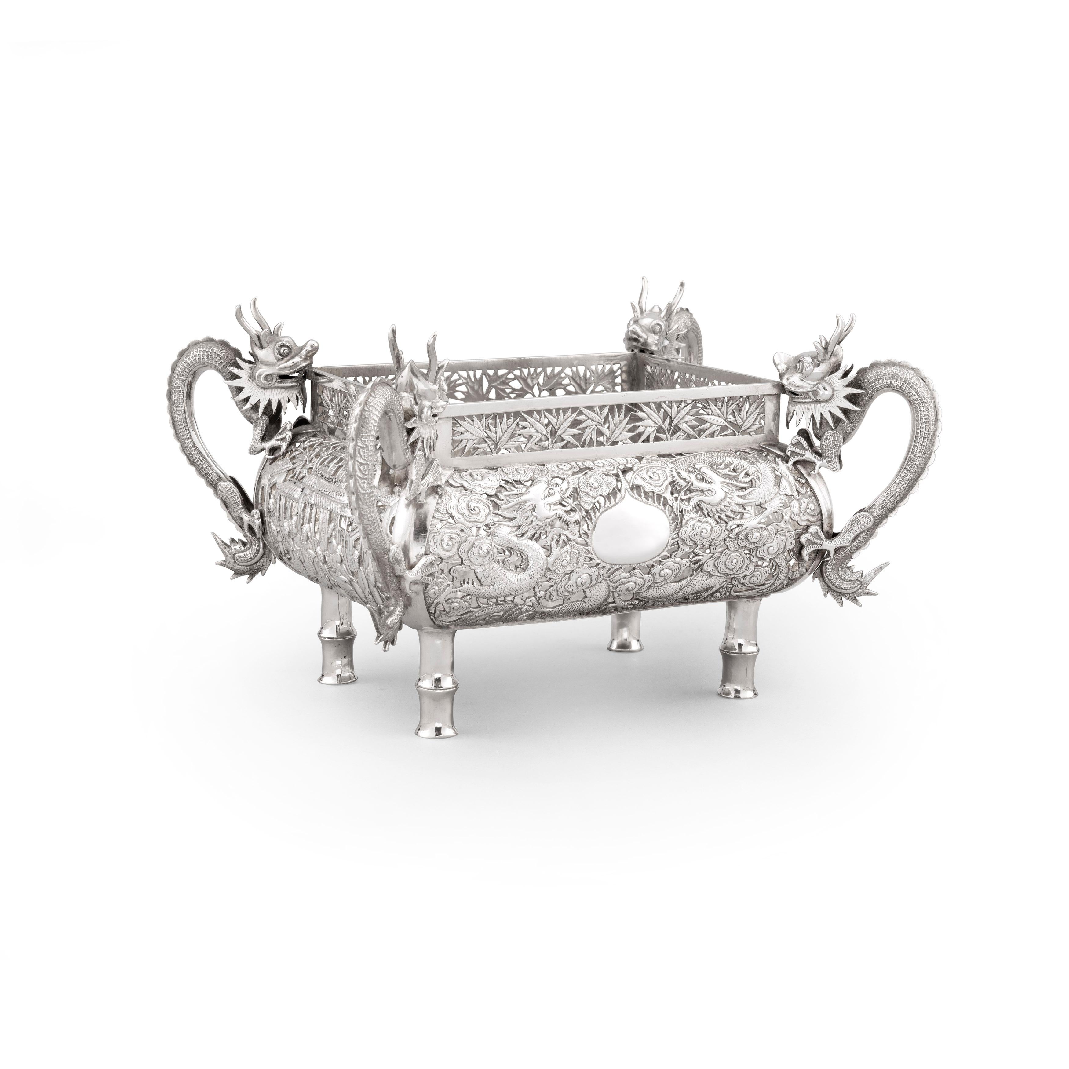 A Chinese Export Silver Jardiniere circa 1890, of rectangular form and variously pierced to all four sides. The side with the vacant cartouche has two opposing dragons separated by a flaming pearl; and the three other sides are pierced and decorated