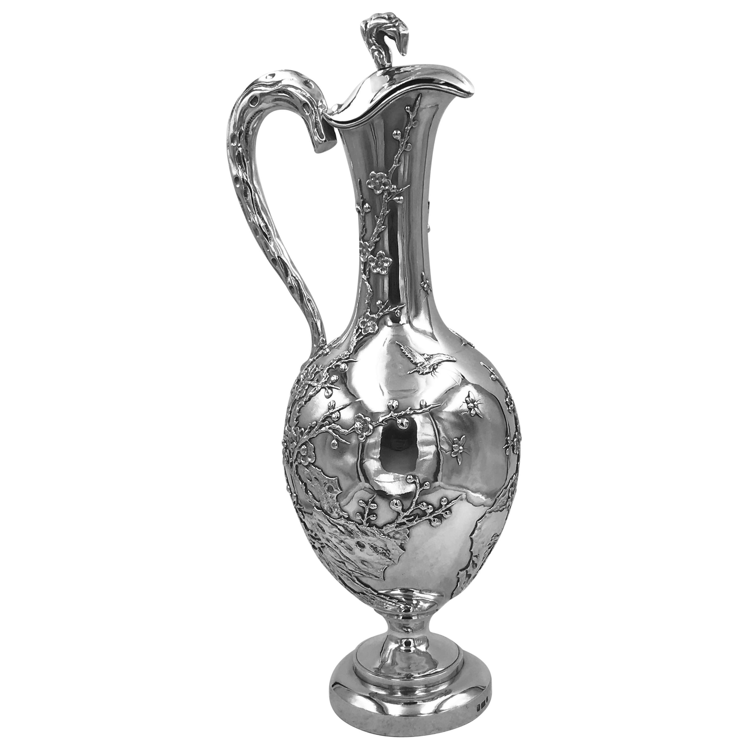 Chinese Export Silver Jug or Ewer, profusely decorated with applied bamboo and moths on a plain background. It has a hinged lid, round collet foot, and the handle and finial are formed as sections of branch. Marked with WH, for Wang Hing  '宏兴‘ which