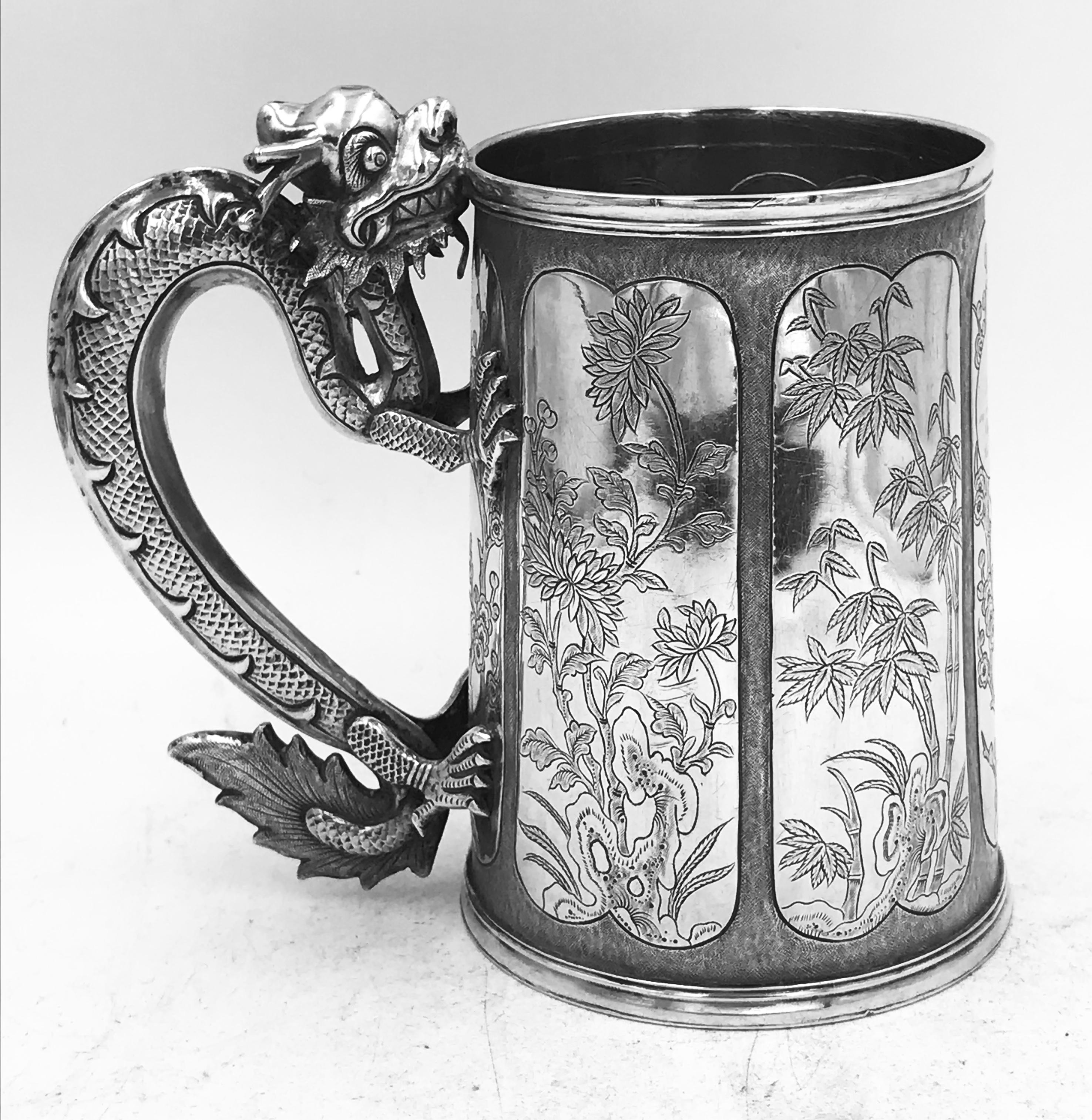 A Chinese export silver mug with flowers and foliage engraved within decorative panels; and a dragon handle. Marked with LC, for Leeching, 利升 (LiSheng), an important retailer in Canton who began in the 1840s and expanded to sell in Hong Kong in
