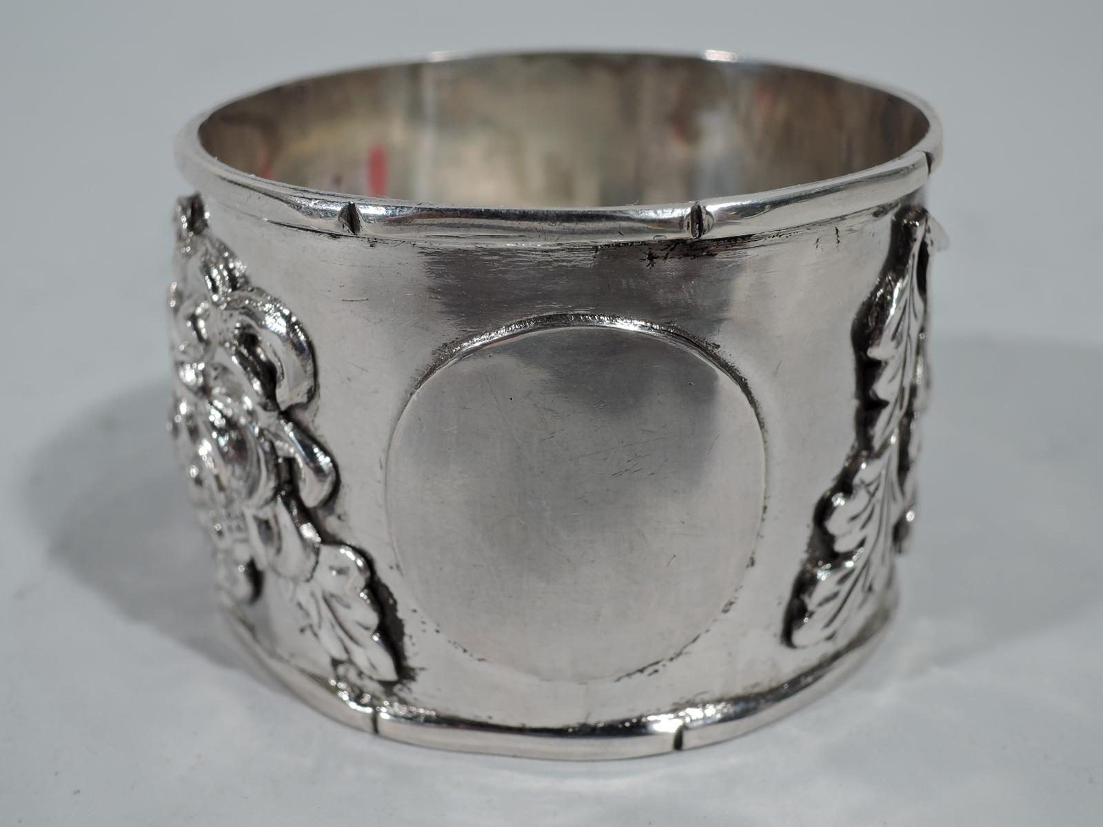 Chinese export silver napkin ring. Applied blossoming prunus branch between bamboo rims. Applied circular frame (vacant). Hallmarked. Weight: 1.7 troy ounces.