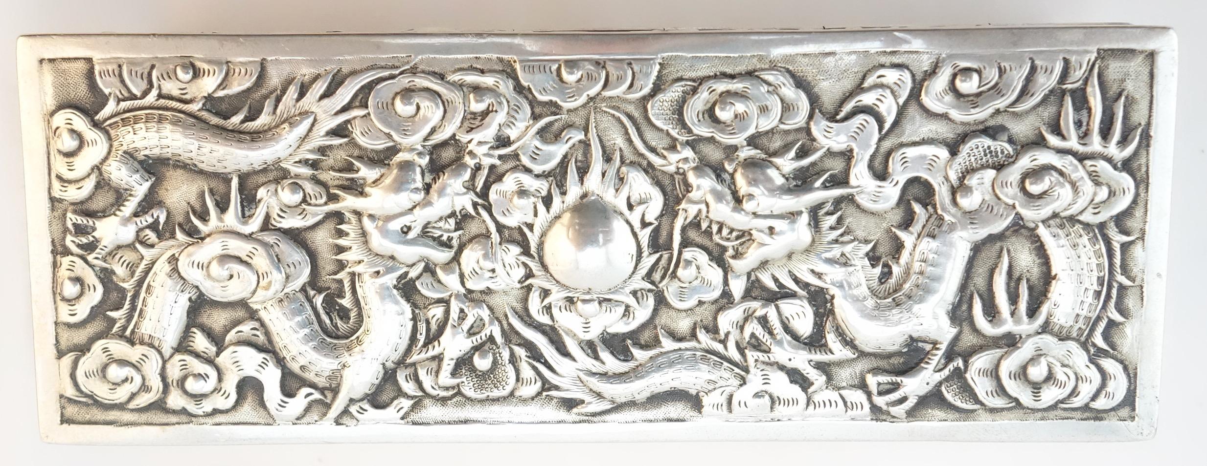 Chinese export silver openwork and repousse box depicting traditional design of dragons and flaming pearl. The box is very finely executed by hand with sharp design elements. It is marked 