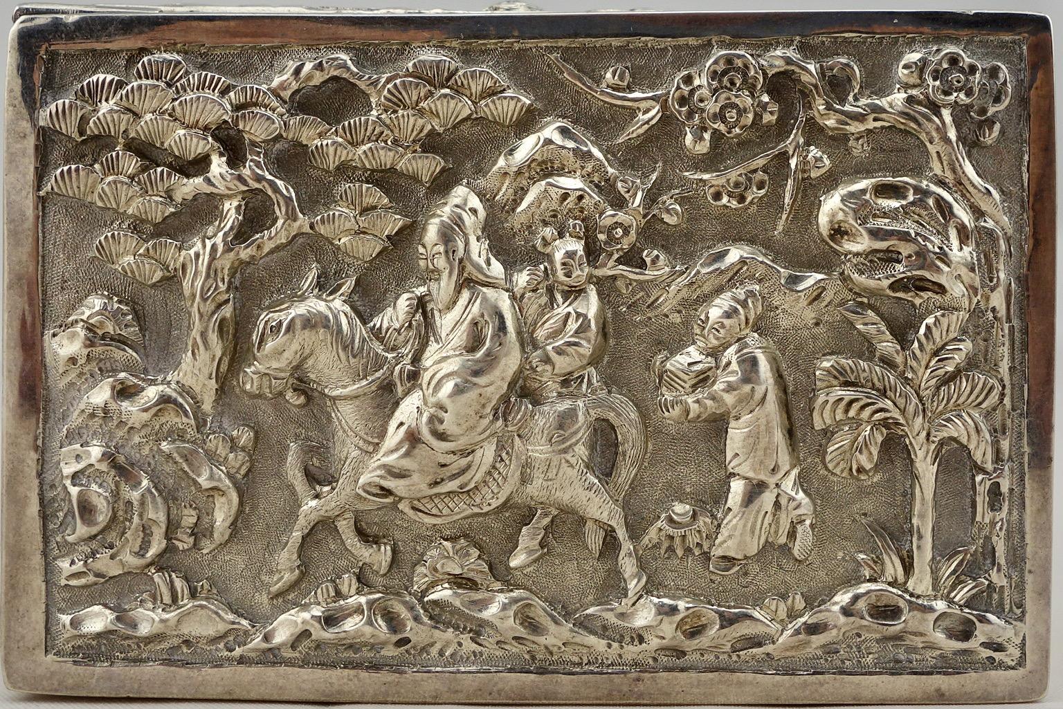 Chinese export silver repousse scenic box, depicting traditional scene of a mandarin riding his horse on the cover. The sides are decorated with stylized plant pattern. Marked 