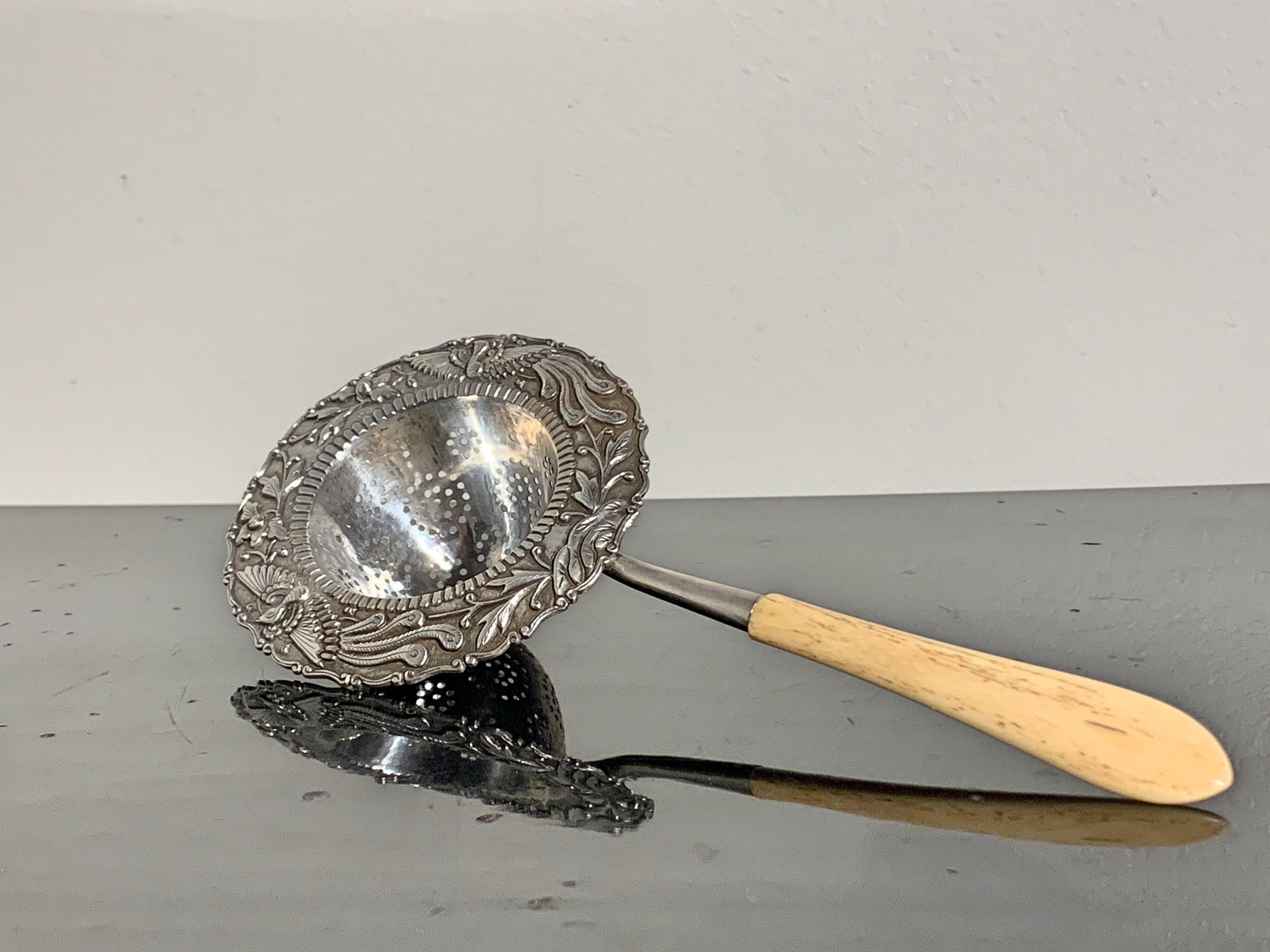 A fine Chinese export silver tea strainer for the Southeast Asian market, featuring a bone handle, late 19th century, China.

The tea strainer crafted of repoussé silver with a design of phoenixes in flight and holding flowering branches. The