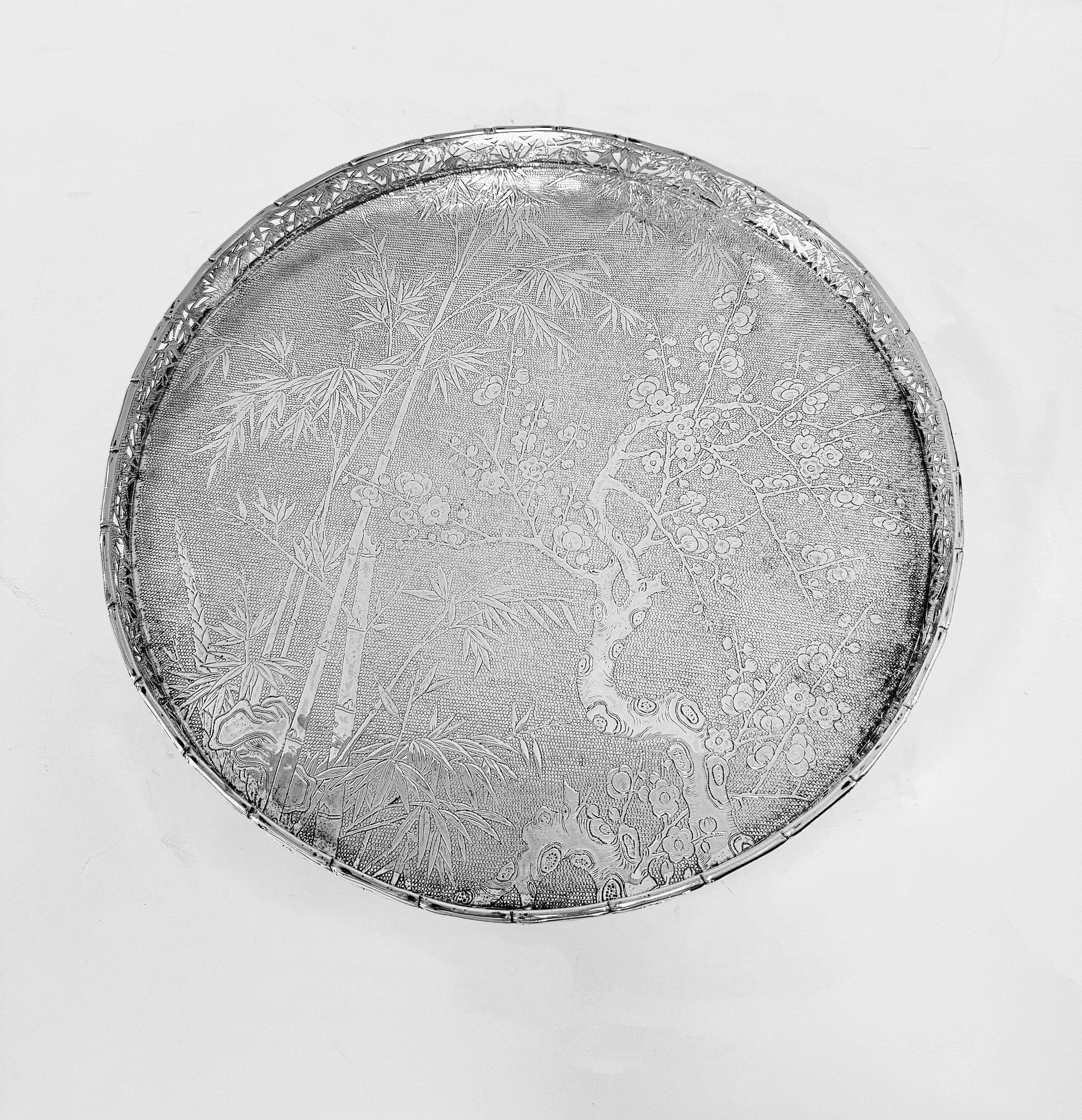 Bandeja/palangana de plata china de exportación, hacia 1890, cincelada y grabada con bambú y flor de pruno sobre fondo mate, con galería de bambú perforada y 3 pies estriados. 
Vendido al por menor por Wang Hing y fabricado por Sui Chang (遂昌).
746g