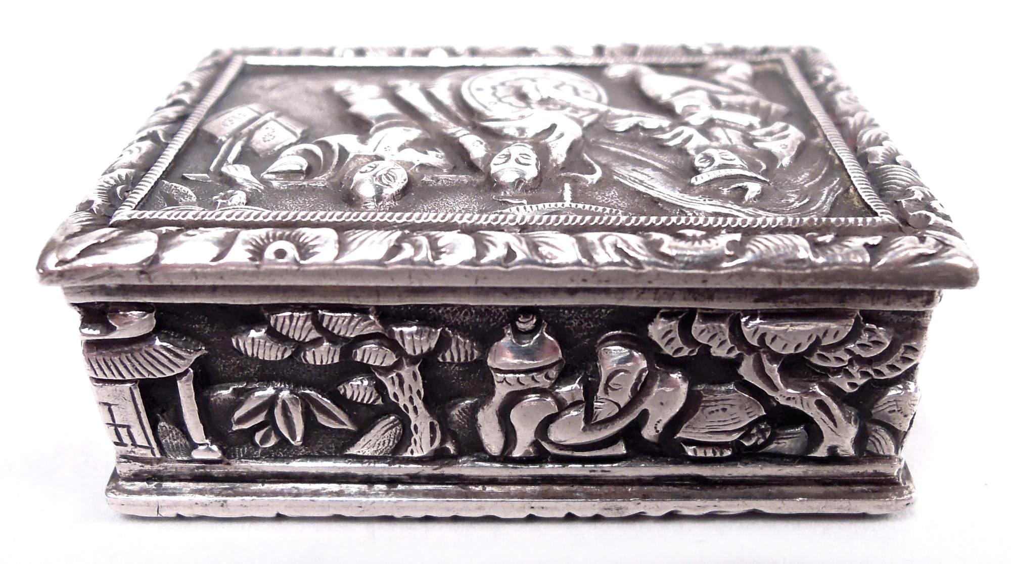 Chinese export silver vinaigrette. Rectangular with hinged cover. Scenes of indigenous life in low relief. Interior gilt with hinged grill; engraved presentation on cover: “E. E. W. N. / from / H. P.” Marked “CUT” for Cutshing, a Canton retailer.