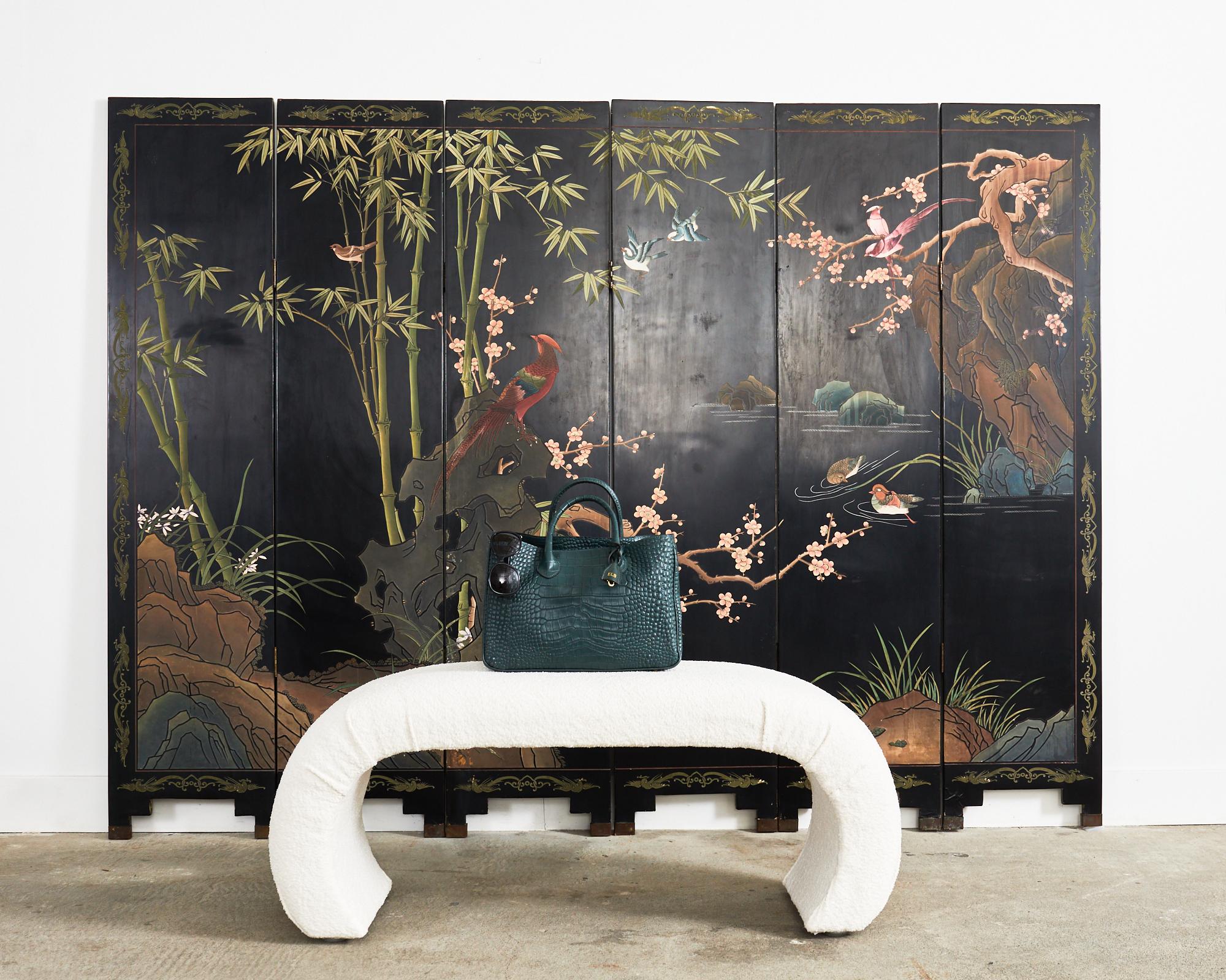 Charming Chinese export lacquered coromandel screen featuring a colorful bamboo and plum blossom water landscape with flora and fauna. The six-panel screen has thick layers of lacquer incised and painted with natural pigments in pastel style colors.