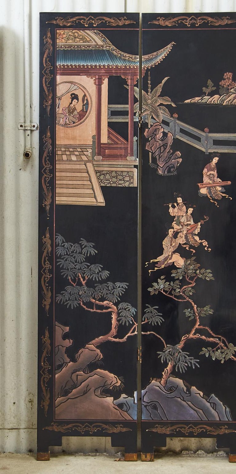 Exceptional mid-century Chinese export coromandel screen featuring a pavilion landscape with twelve beauties engaged in leisurely activities. Each panel is ebonized in thick coats of black lacquer and beautifully incised with colored pigments. The
