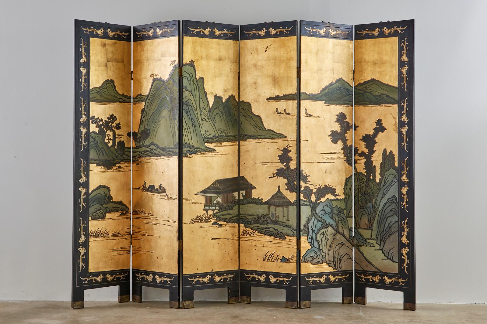Stunning 20th century Chinese export six-panel coromandel screen. Features lacquered panels embellished with squares of gold leaf for a dramatic water landscape scene. The landscape is bordered with stylized images of birds over a black lacquered