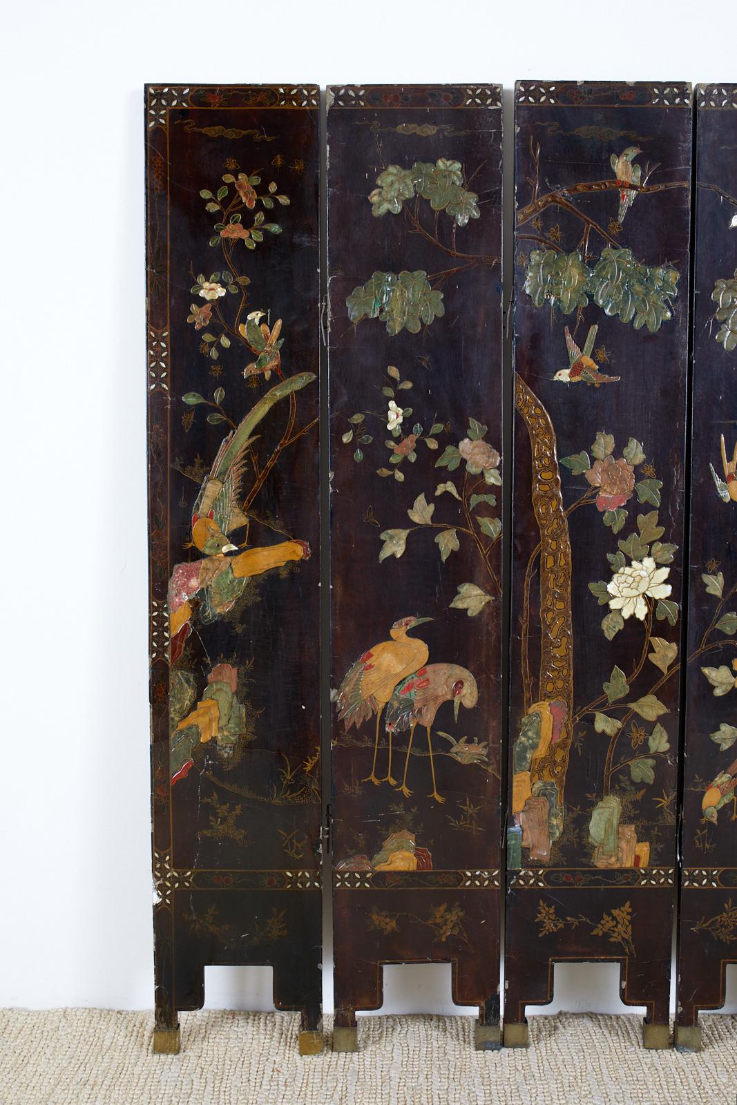 Beautifully distressed Chinese export six-panel coromandel screen featuring moriage lacquered panels of flora and fauna. Each panel is decorated exotic birds, cranes, flowers and trees with a thick soapstone style carved finish. The border is