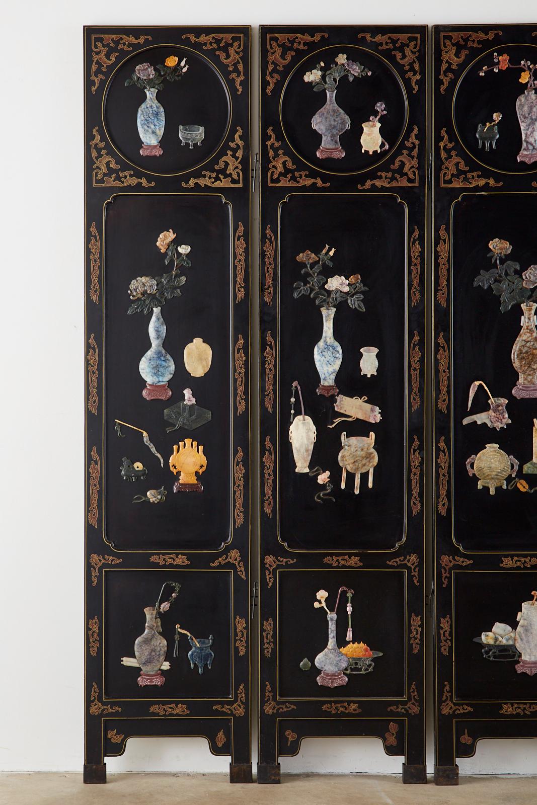 Fantastic Chinese export six-panel folding screen featuring intricately carved scenes of scholars objects, vases, and flowers. Crafted from hardstone and soapstone mounted to lacquered panels and set in parcel gilt decorated windows. Each panel is