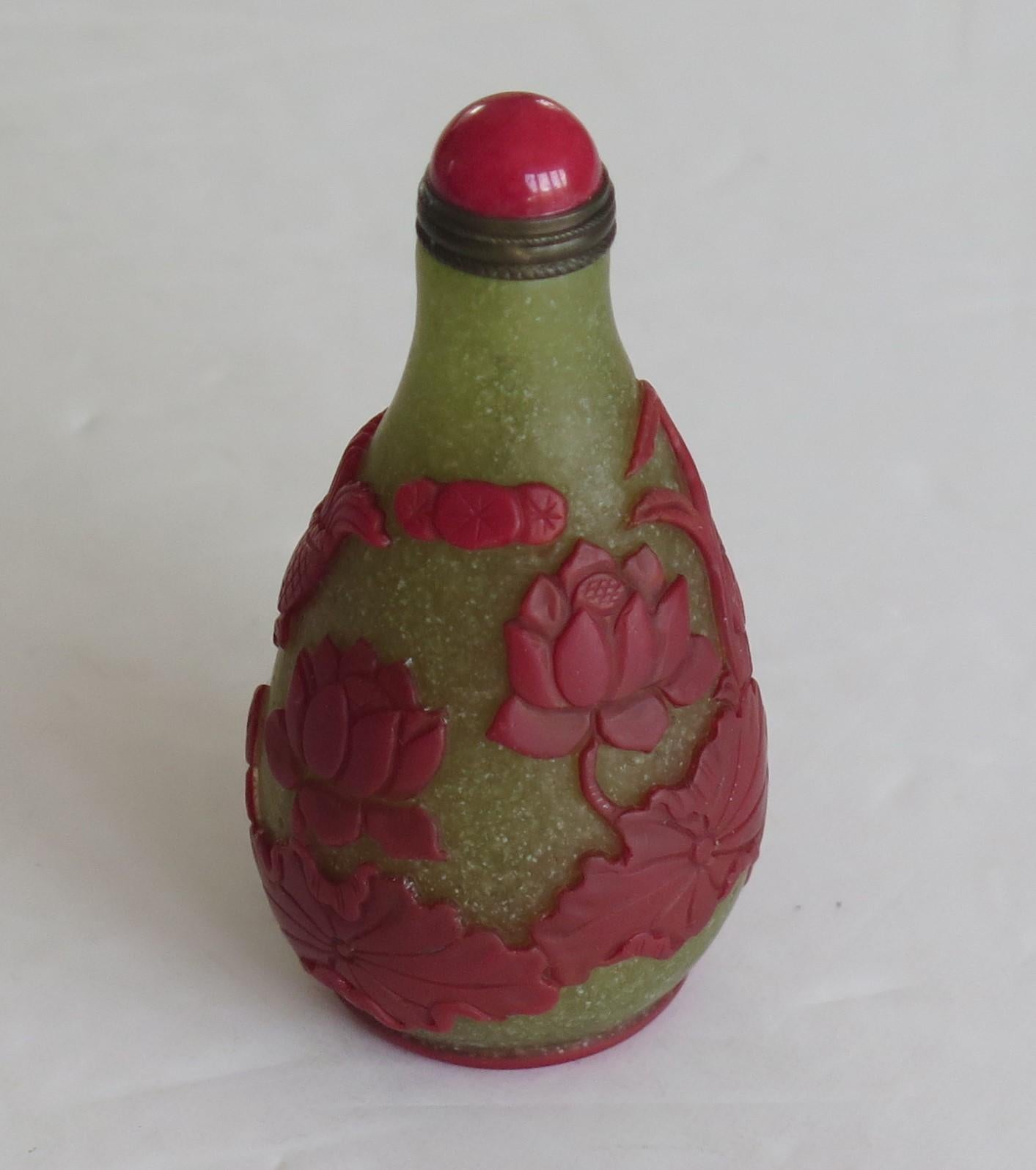 This is a very good Chinese cameo or overlay glass snuff bottle, which we date to circa 1925.

These overlay glass cameo snuff bottles are very decorative and sought after, particularly with this level of excellent carved detail.

It is made of
