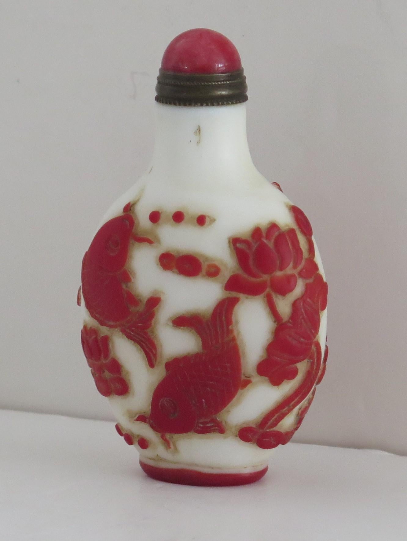 This is a very good Chinese cameo or overlay glass snuff bottle, which we date to circa 1925.

These overlay glass cameo snuff bottles are very decorative and sought after, particularly with this level of excellent carved detail.

It is made of