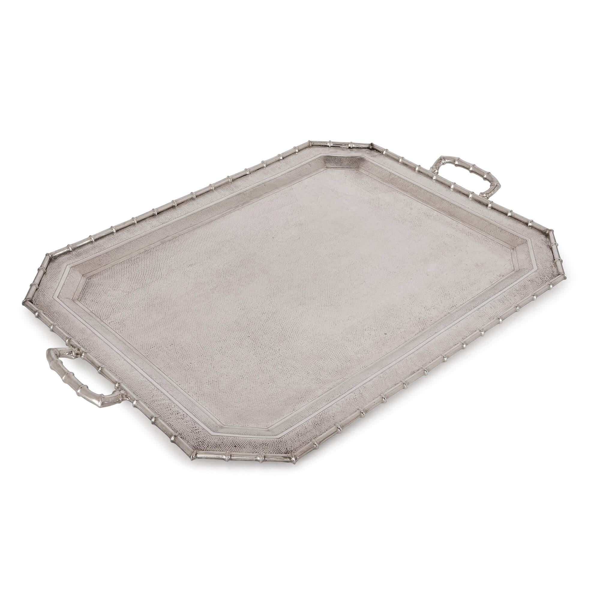 This silver tray is a beautiful piece of tableware, which skilfully blends Eastern and Western decorative styles. It has been decorated with a twisted bamboo edge, bamboo handles and the tray base has been carefully hammered to give the piece a