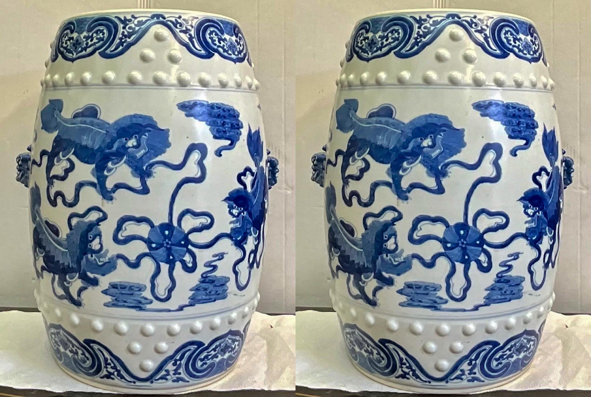 This is a pair of Chinese Export style hand painted ceramic blue and white garden stools or side tables. They depict running blue foo lions and have blue lion handles. They are in very good condition with no chips or cracks. Top diameter is 11